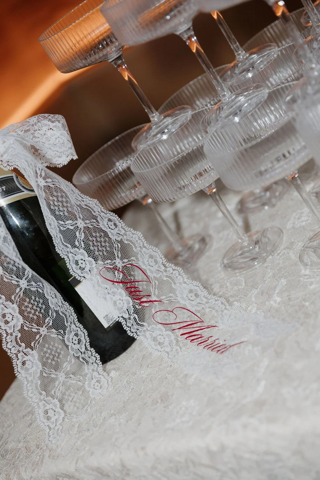 Champagne bottle with a lace ribbon bow with the label "Just Married" in red lettering