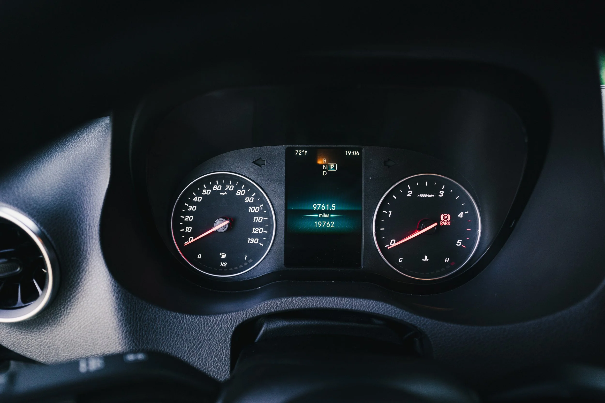 Close-up view of a car's instrument cluster showing the speedometer, tachometer, odometer reading 19,762 miles, and other indicators, with a digital display in the center.