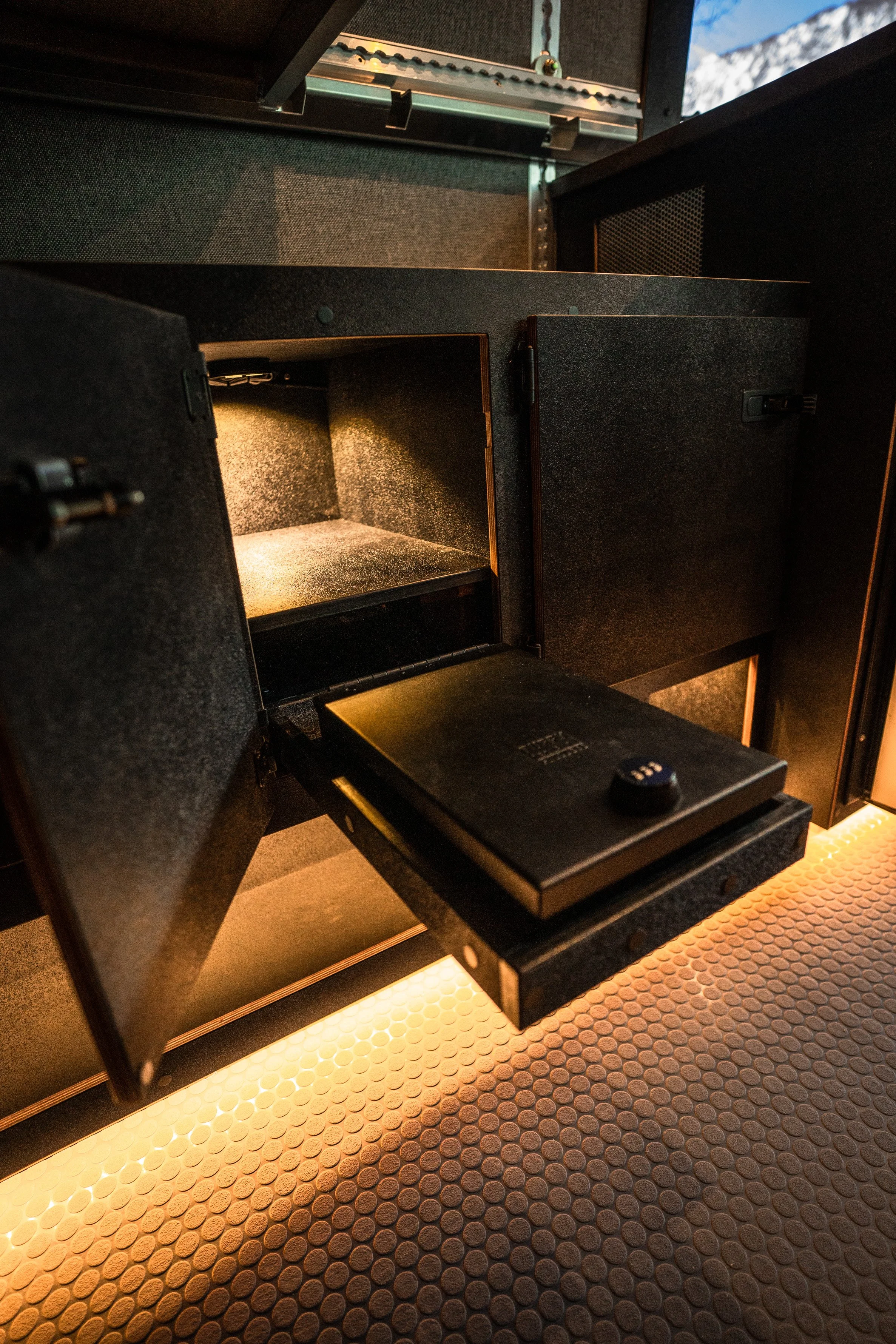 Open safe deposit box with a digital combination lock inside a secure room.