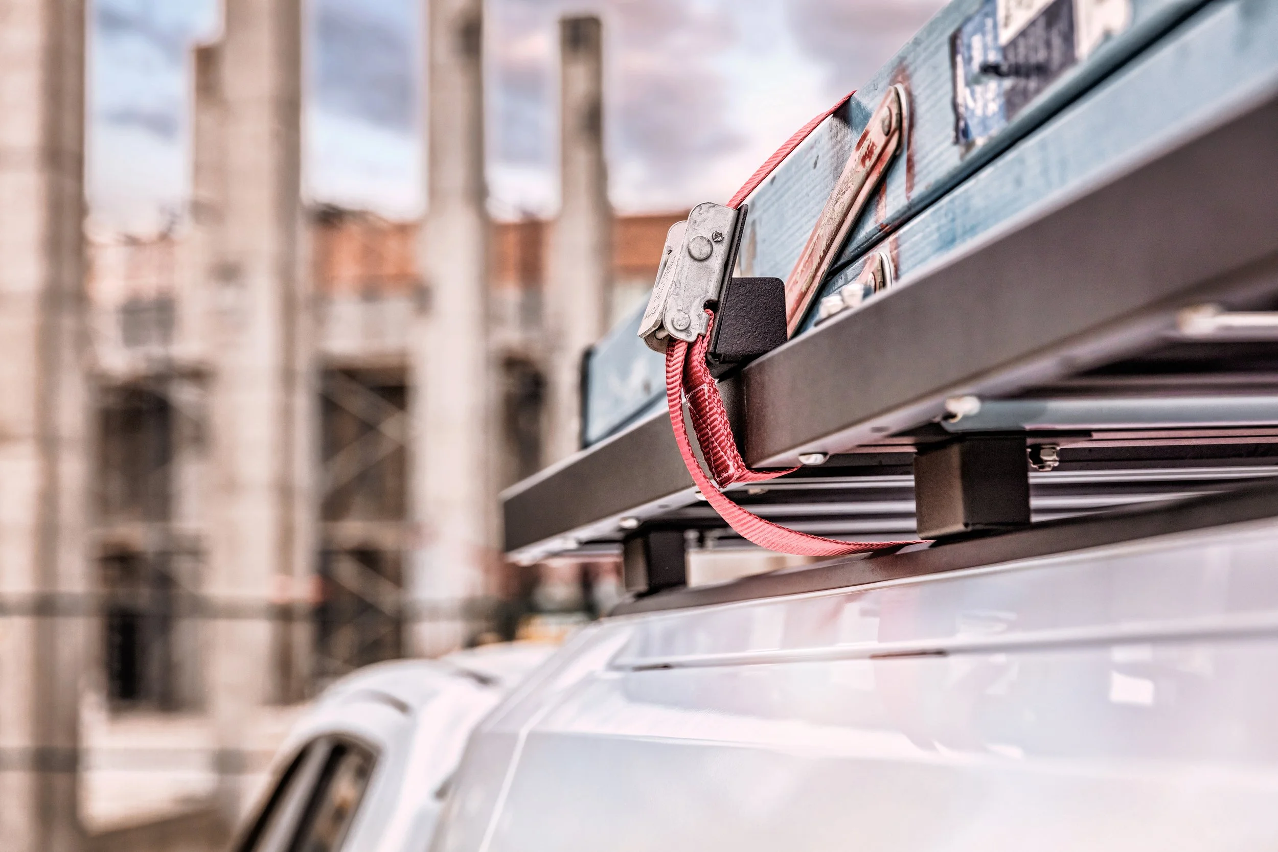 A close-up of a SmartCap topper with a roof rack and materials strapped to the roof.