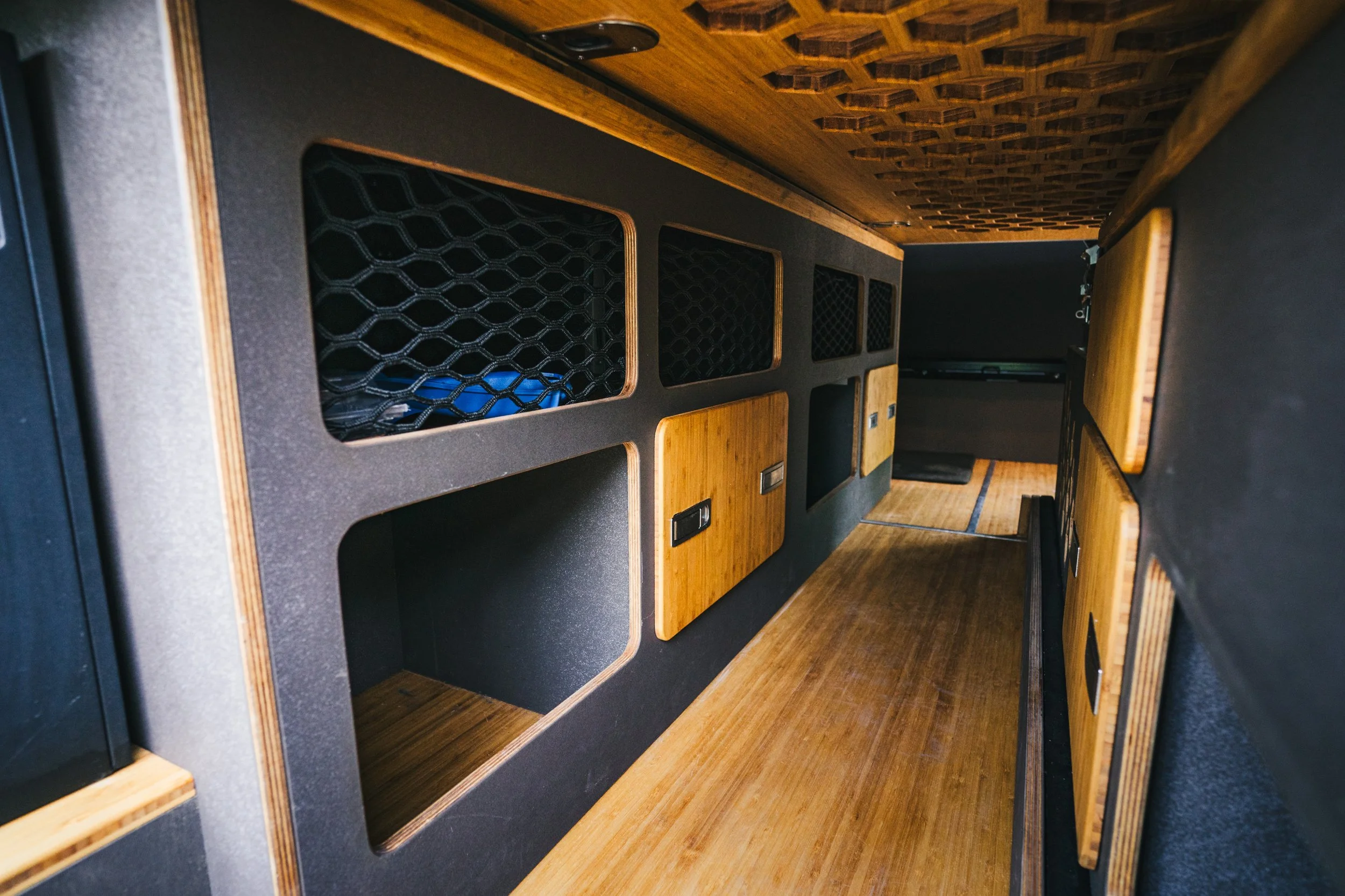 Interior of a van with black and wooden storage compartments