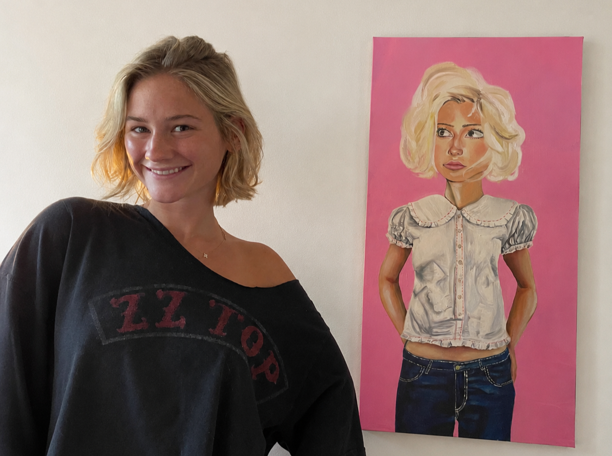 Young woman with blonde hair smiling next to a portrait painting of herself with a pink background.