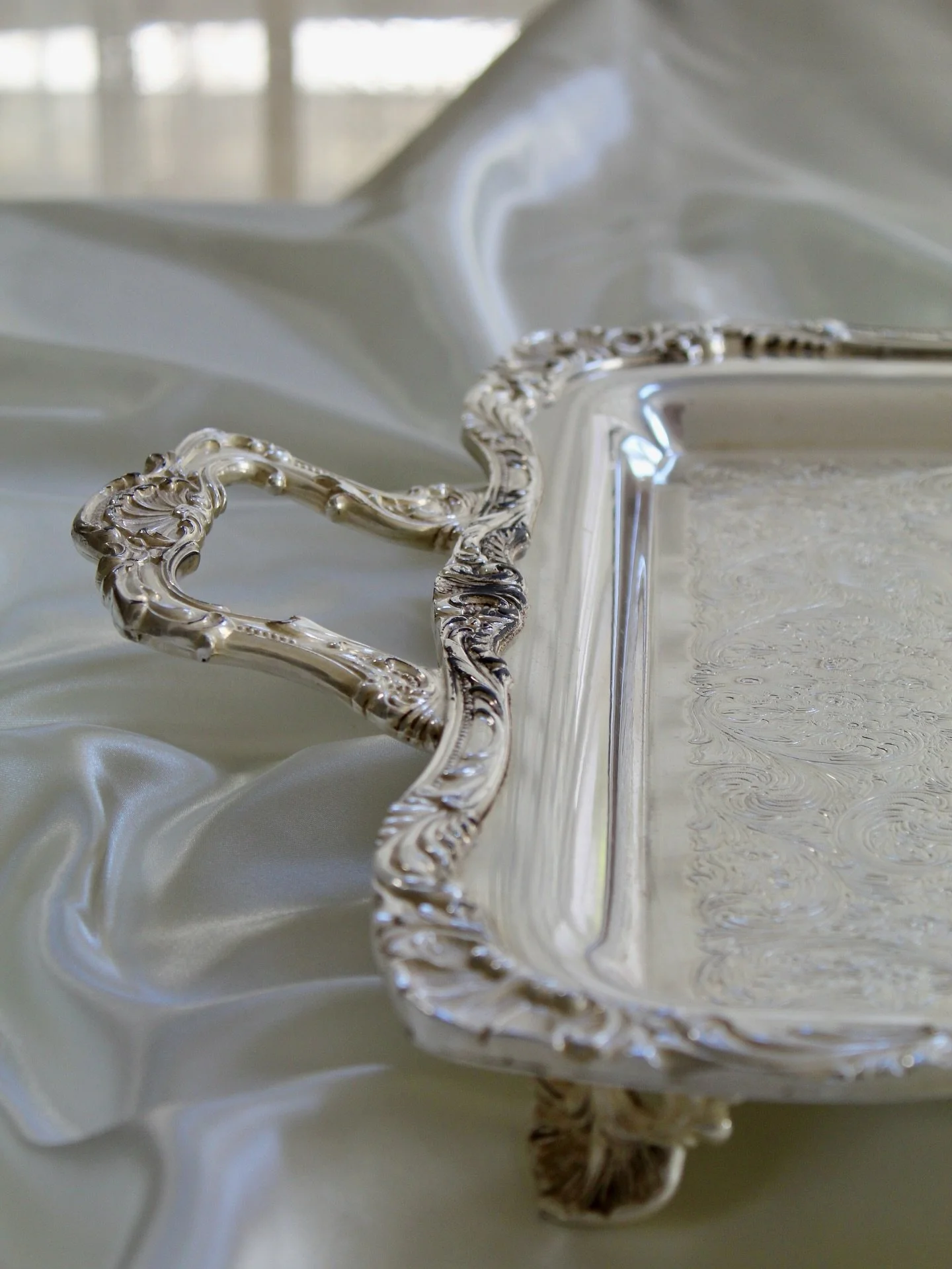 Literal beauty in the unpolished &mdash; this vintage WM Rogers &amp; Sons 28&rdquo; serving tray is a stunner. The largest of its kind on hand, this item features a heavy silverplate tray, spring flowers engraving, raised feet, and ornate twin handl