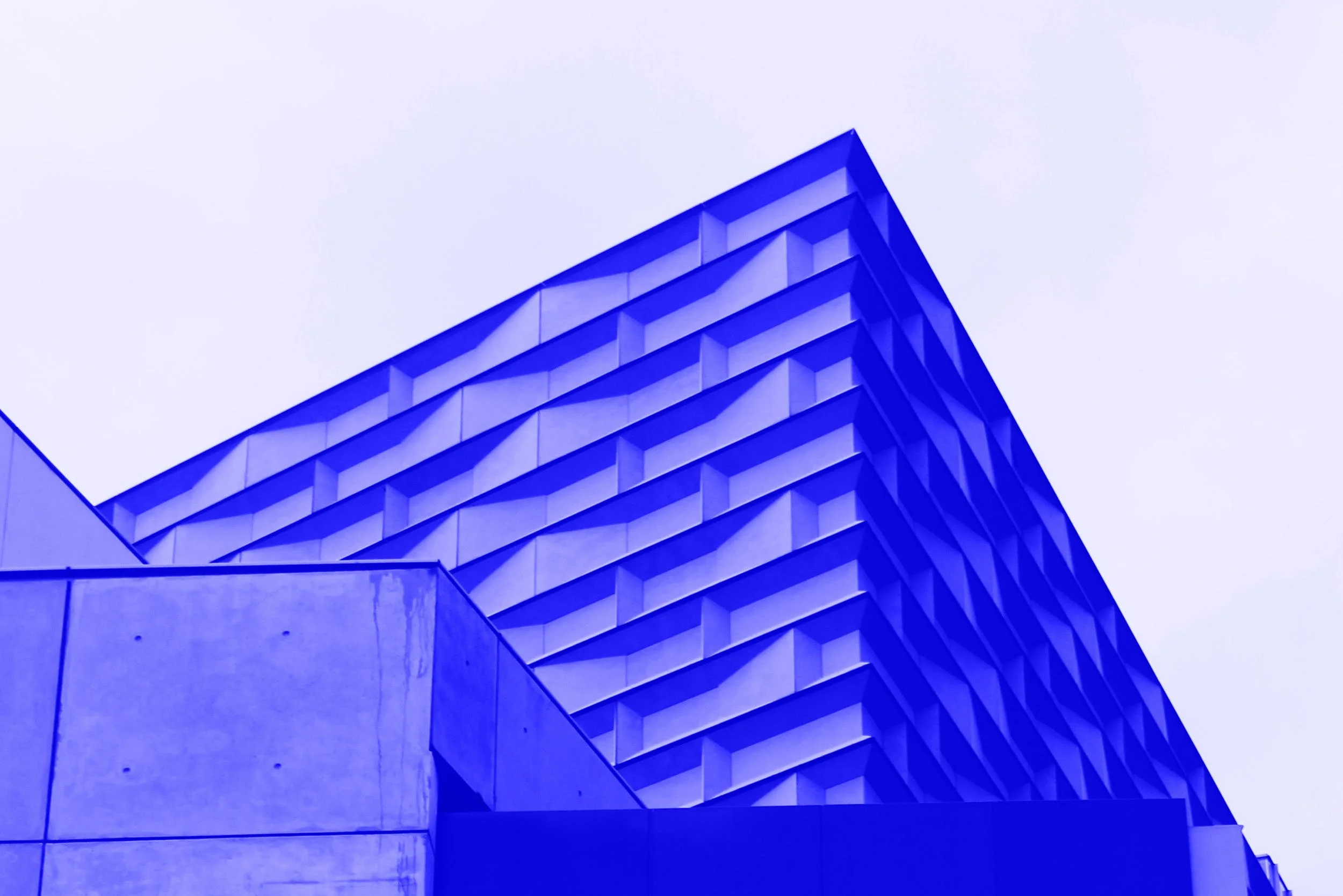 Modern building with geometric, angular design and blue lighting accents.