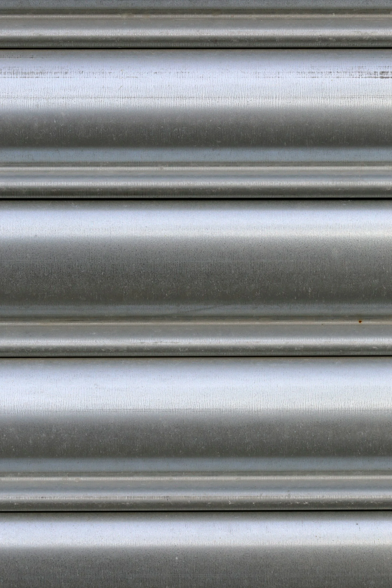 Close-up of a gray metal roller shutter with horizontal ridges.