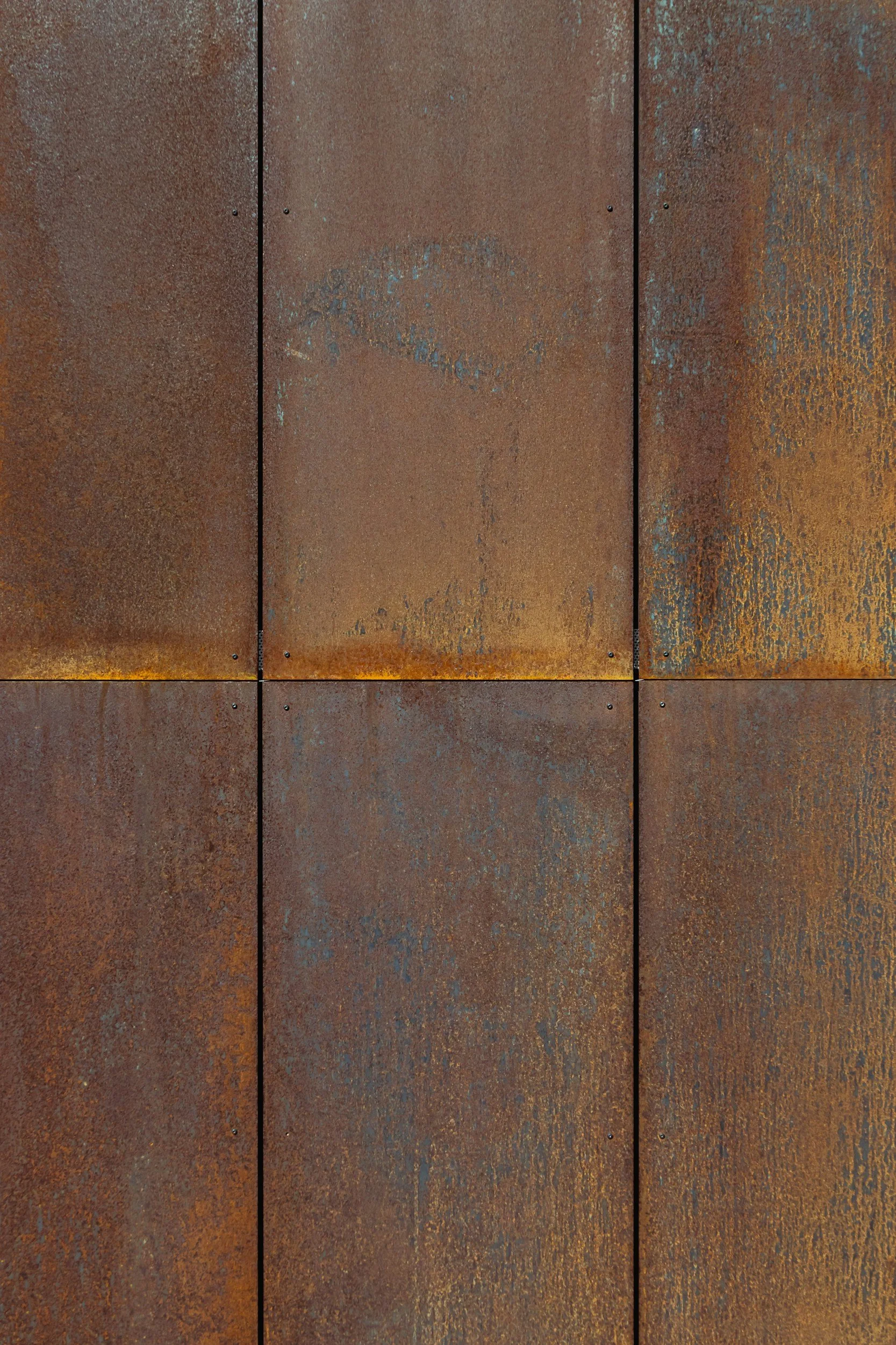 A close-up of weathered rusted metal panels arranged in a grid pattern.