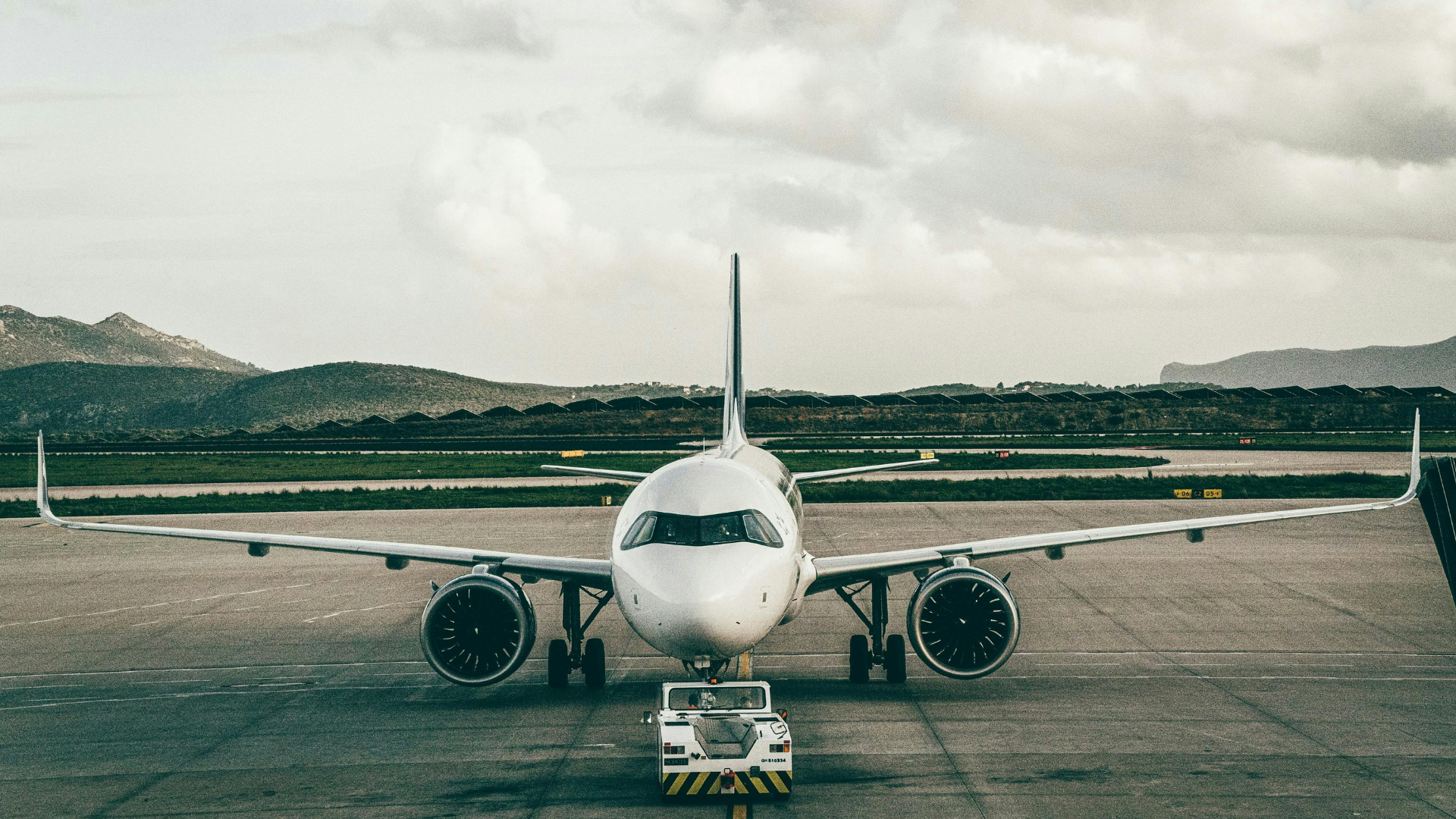 Flygplan flyger över Skyhall på Orlando International Airport vid solnedgång.