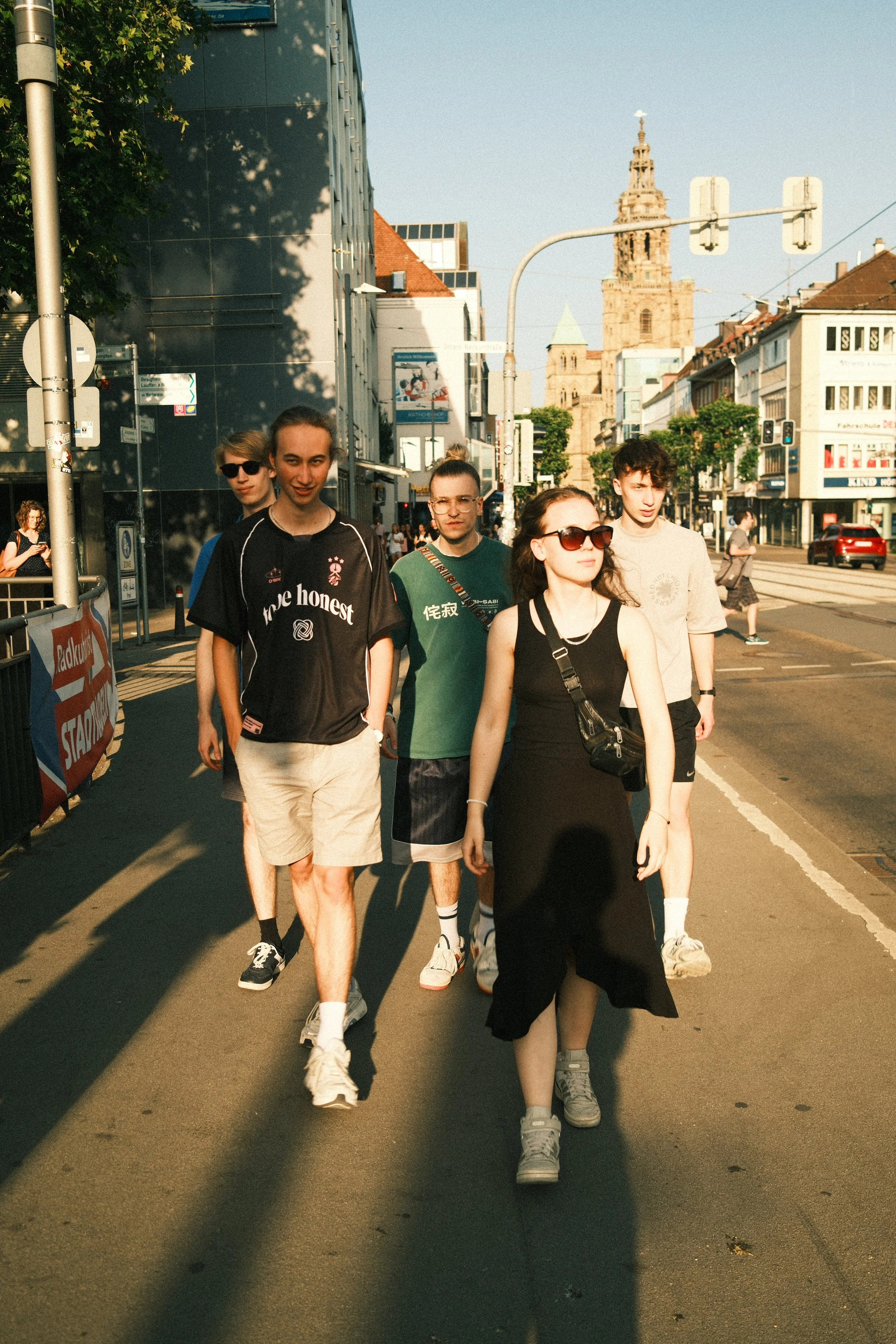 Eine Gruppe junger Menschen, aka optical flow, geht in der Stadt Heilbronn spazieren, während die Sonne scheint.