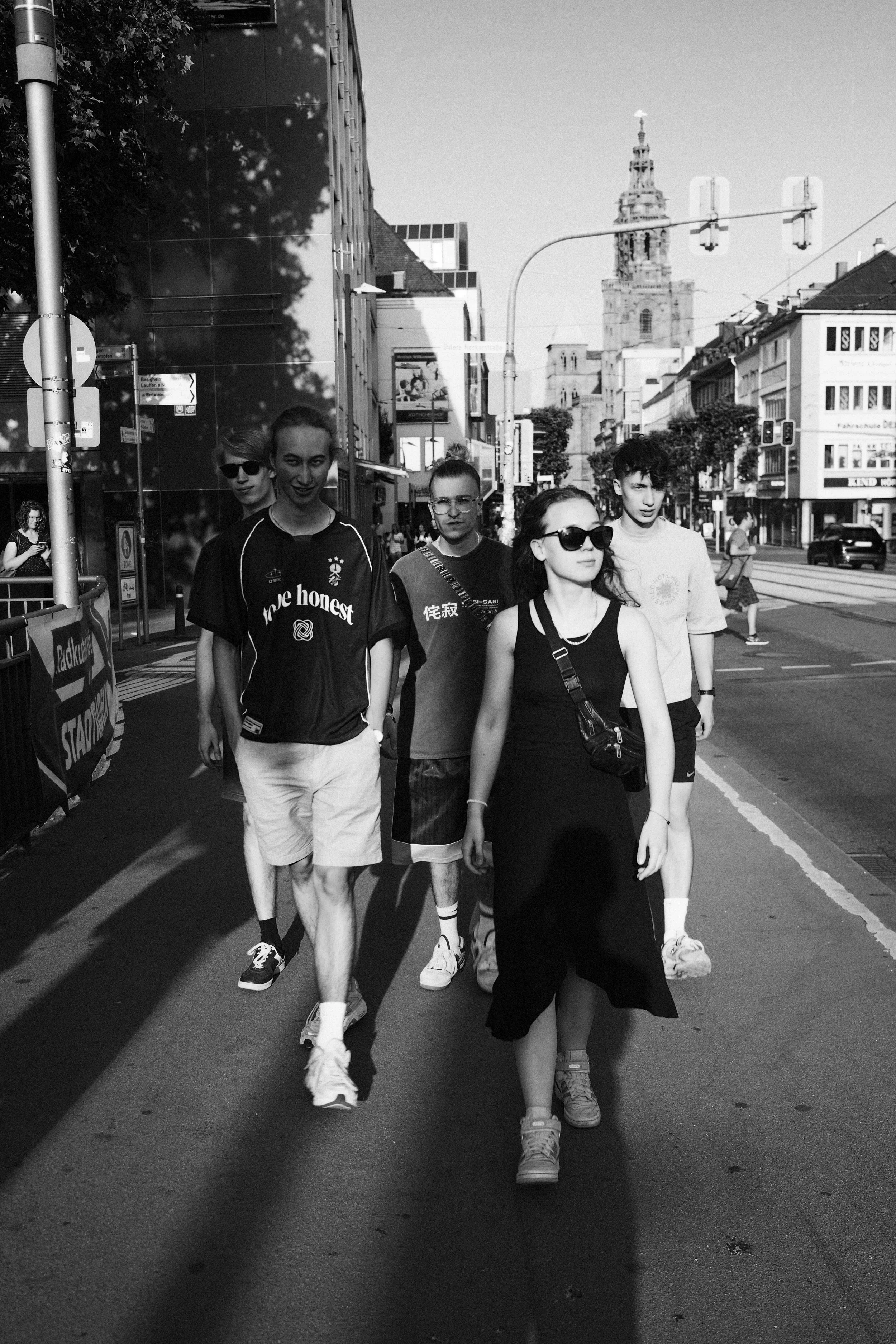 Eine Gruppe junger Menschen, aka optical flow, geht in der Stadt Heilbronn spazieren, während die Sonne scheint.