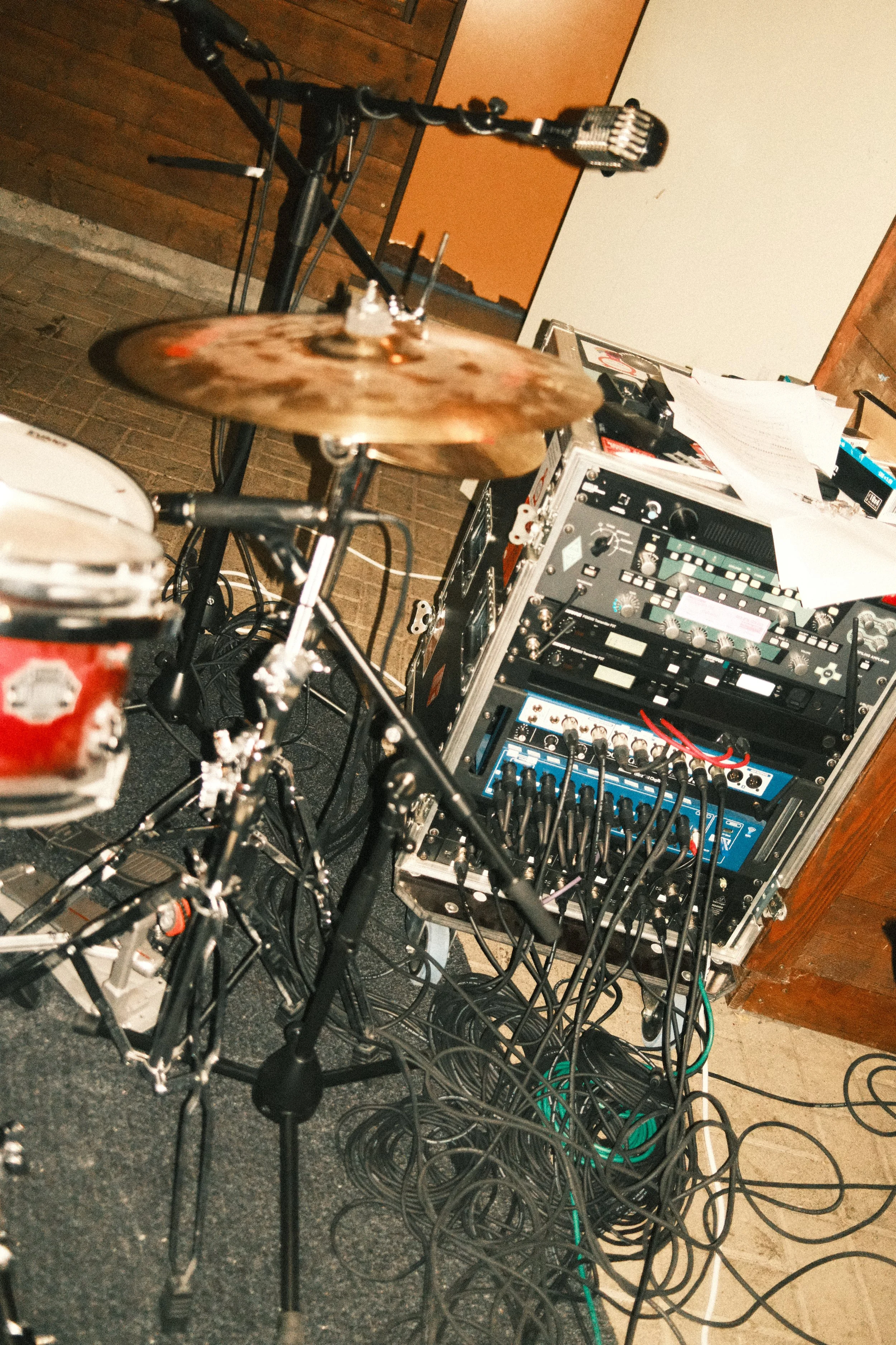 Musik-Ausrüstung mit Schlagzeug, Mikrofon und Verstärkern in einem Probenraum.