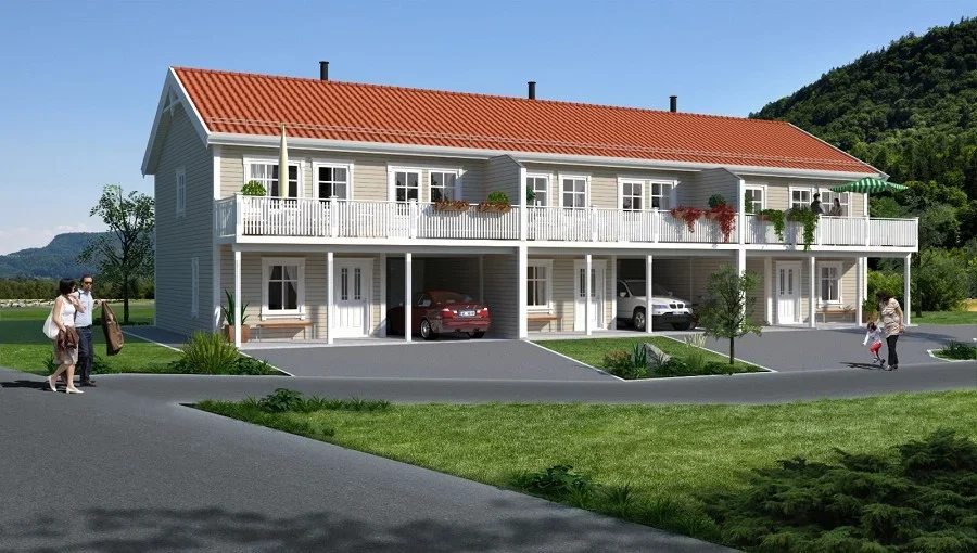 En moderne flerfamiliebolig med parkering under balkongen, omgitt av grøntarealer og bakke med fjell i bakgrunnen.