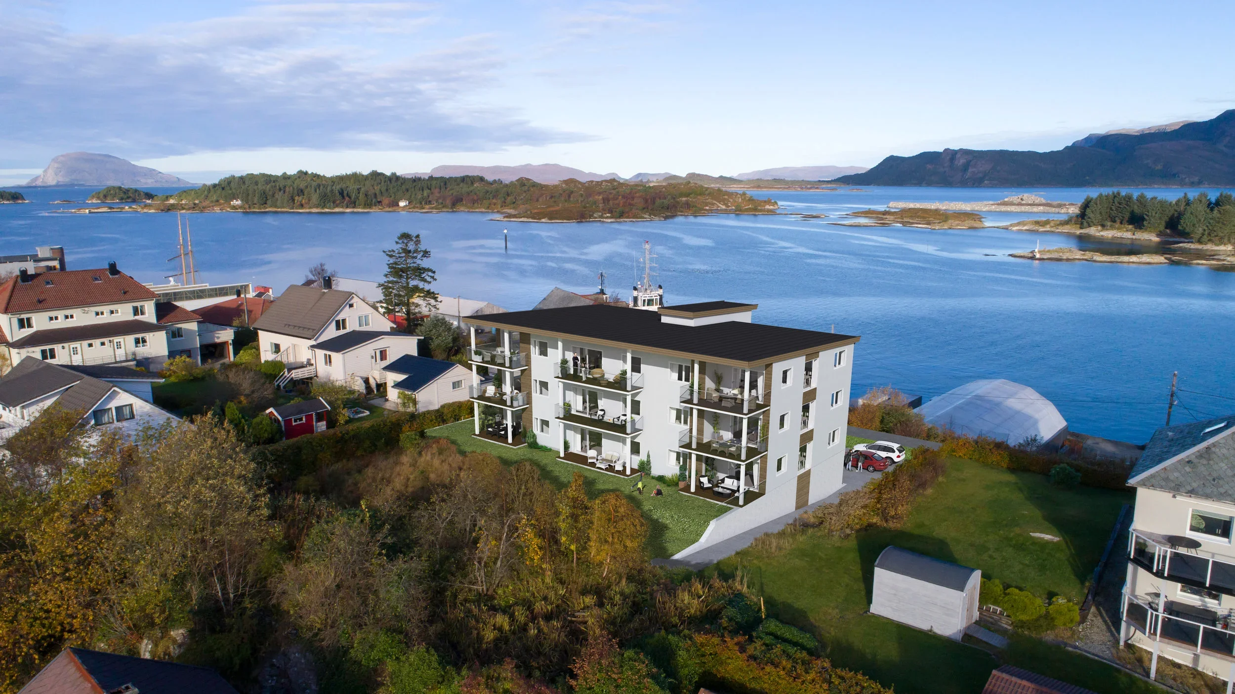 Et bilde av en boligblokk som er under oppføring, med hav og fjell i bakgrunnen.