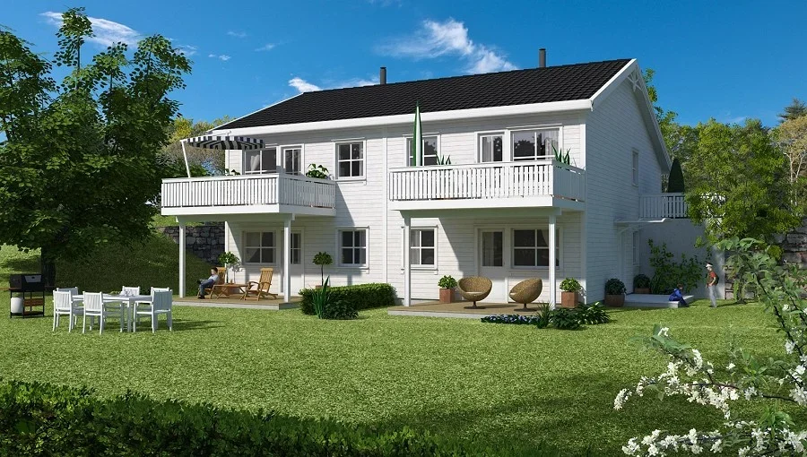 Et hvitt hus med to balkonger i en grønn hage, omgitt av trær og en klar blå himmel.