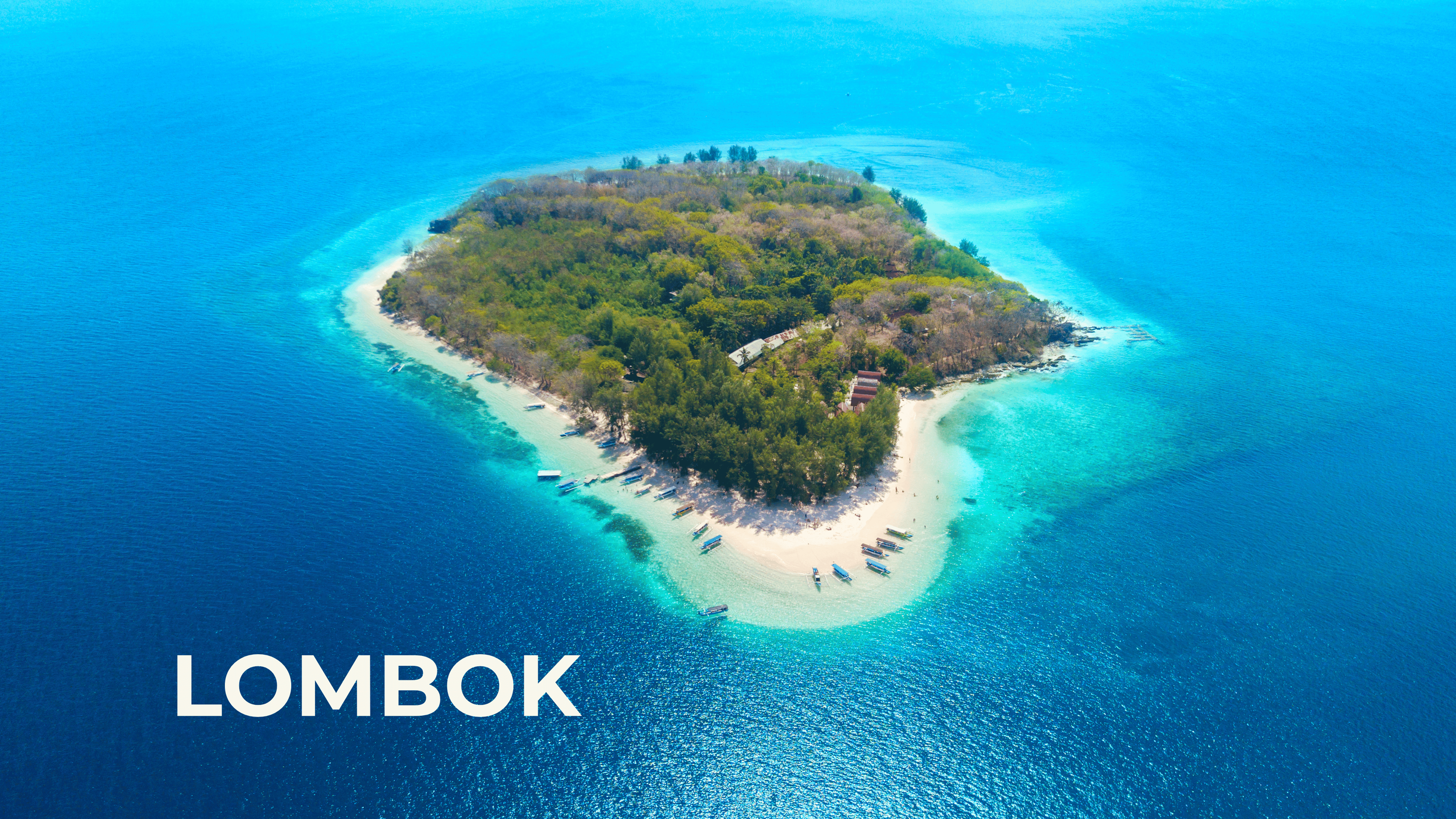 Aerial view of an island surrounded by turquoise waters, with boats docked along the shore and lush greenery covering the island.