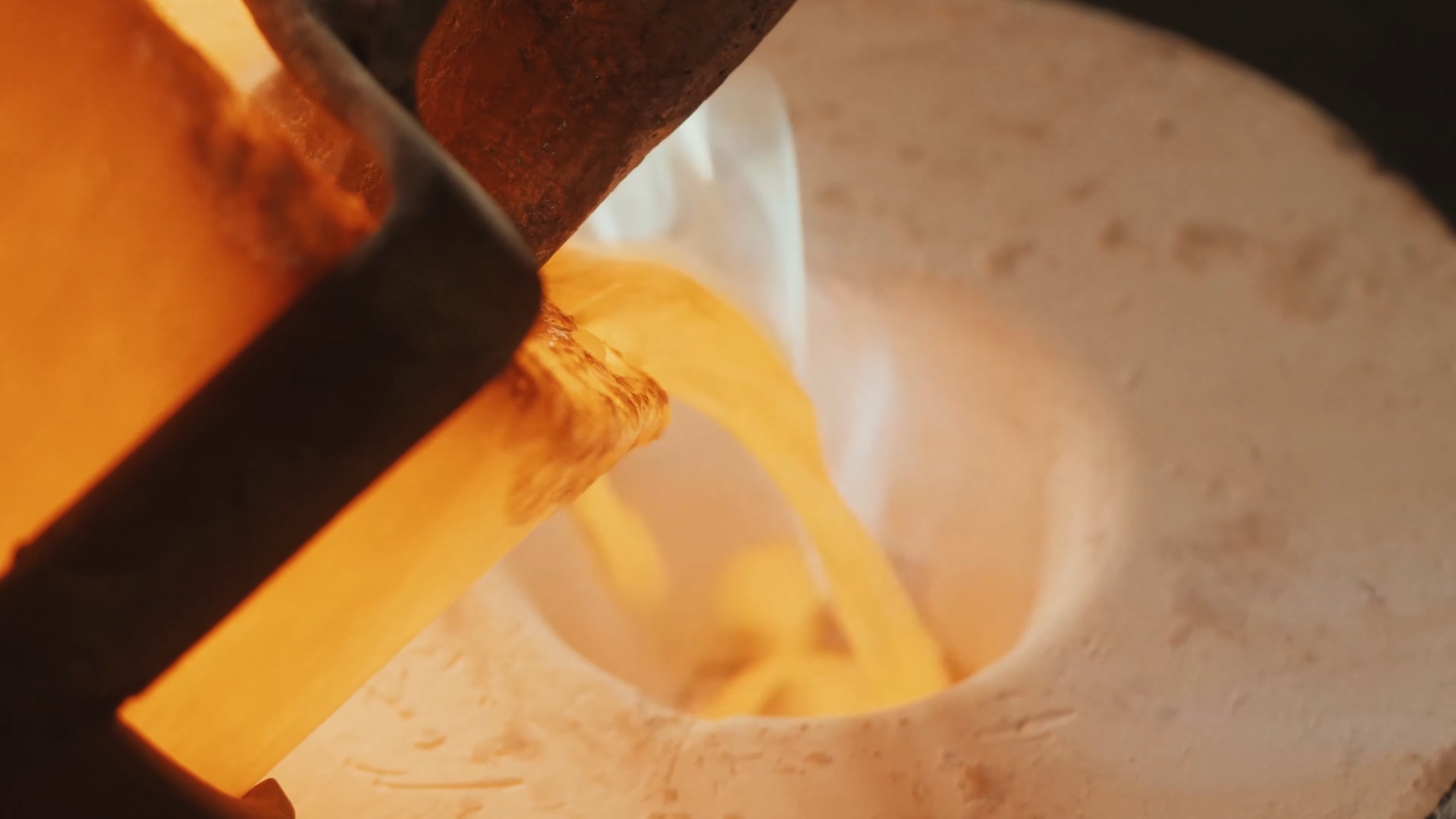 Close-up of dough being rolled out with a metal rolling pin.