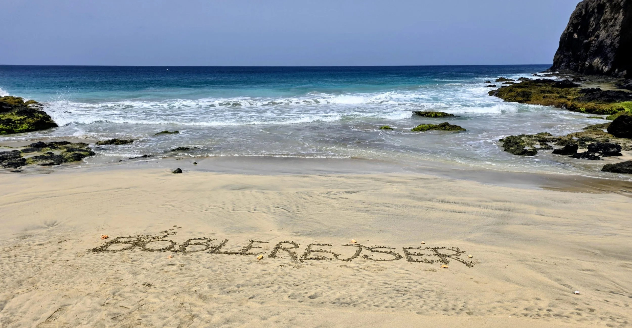 bølgerne møder stranden på Sao Pedro Beach Sao Vicente og der står Boblerejser i sandet på stranden