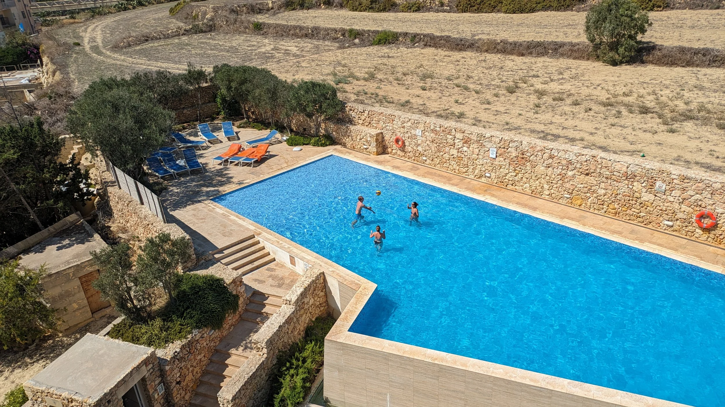 Tre spiller bold i stor pool på Gozo, Malta