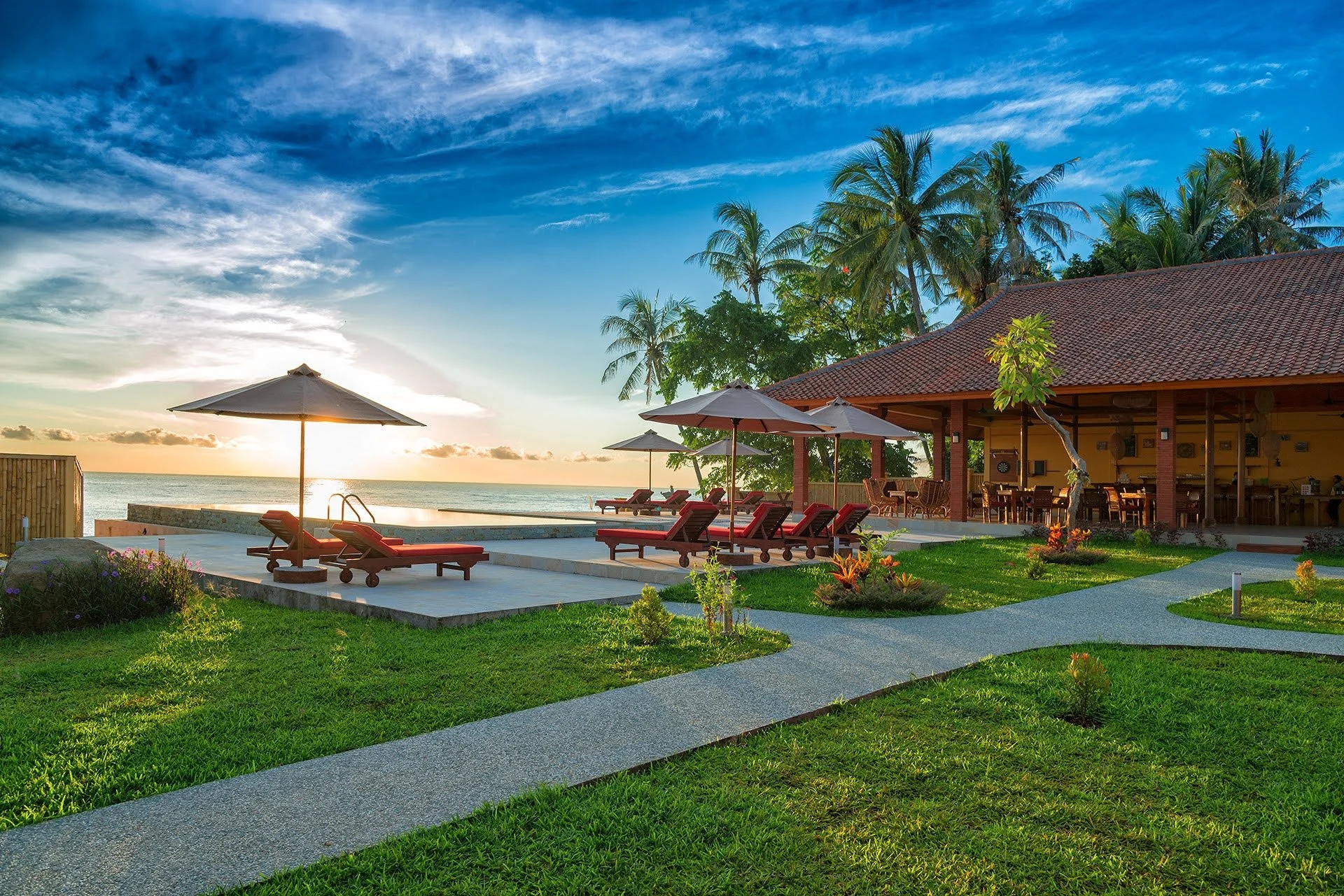 Familievenligt strandresort på Bali med pool og udsigt over havet ved solnedgang – ro, palmer og feriestemning med Boblerejser.