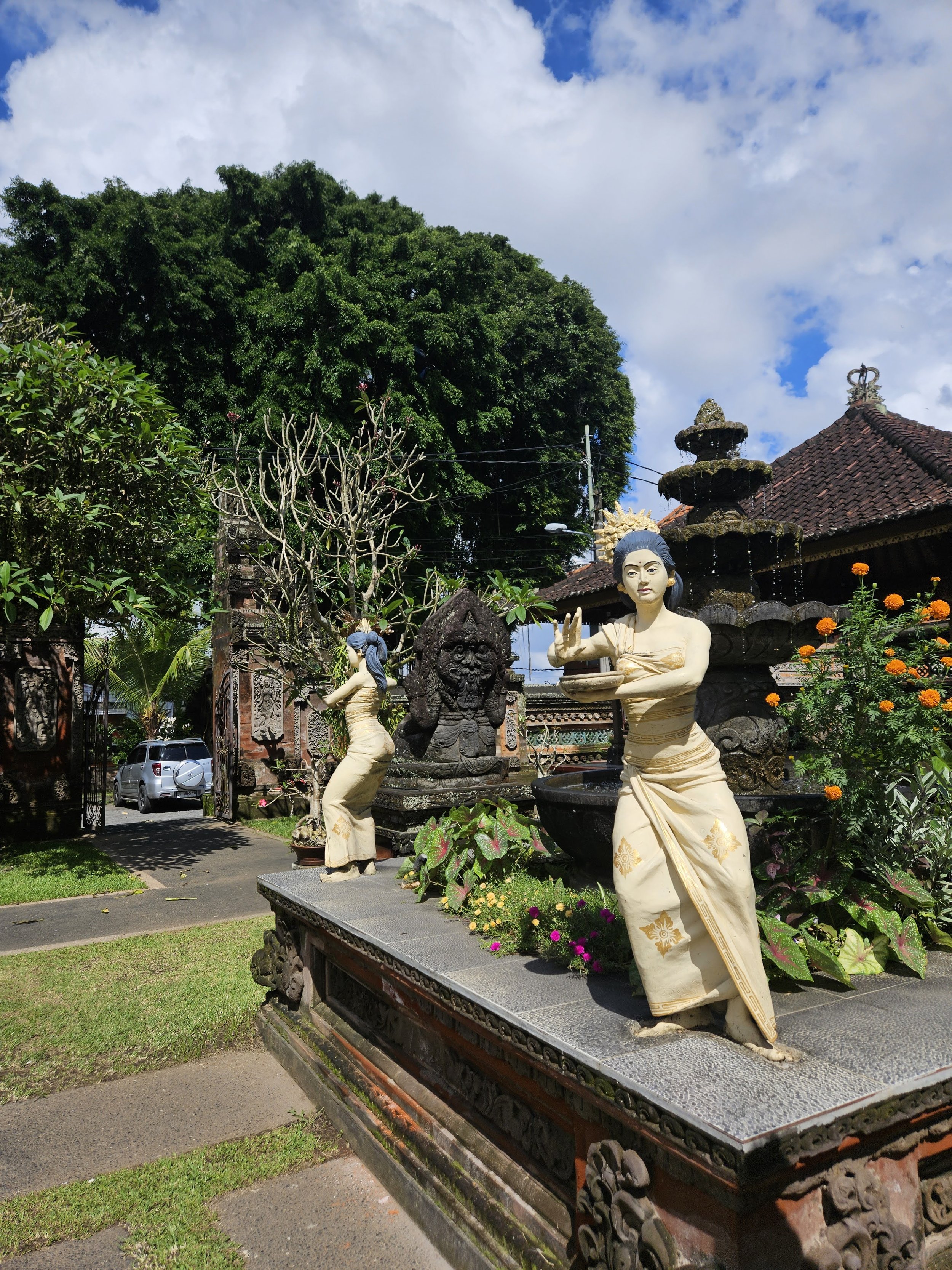 Traditionelle balinesiske danserinder i tempelhave på Bali med sarong og bare fødder