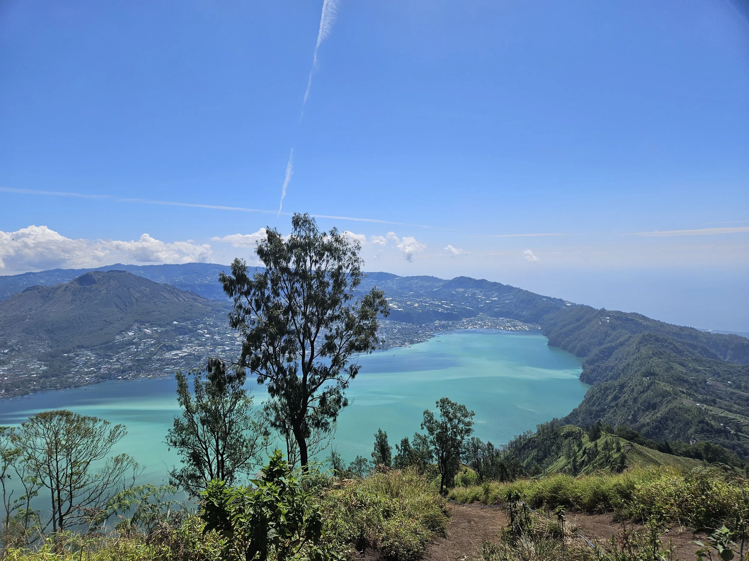 Udsigt fra Mount Batur over turkis vulkansø og bjerglandskab på Bali