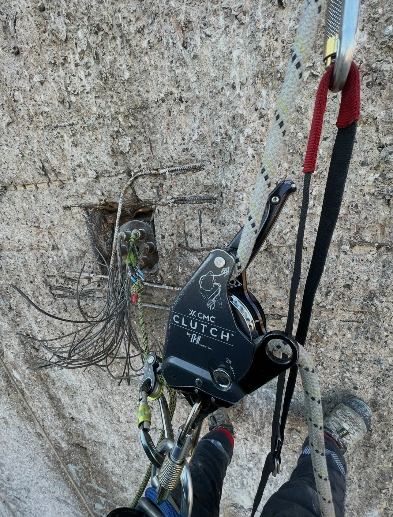 Imbracatura per arrampicata e cordicella su parete rocciosa