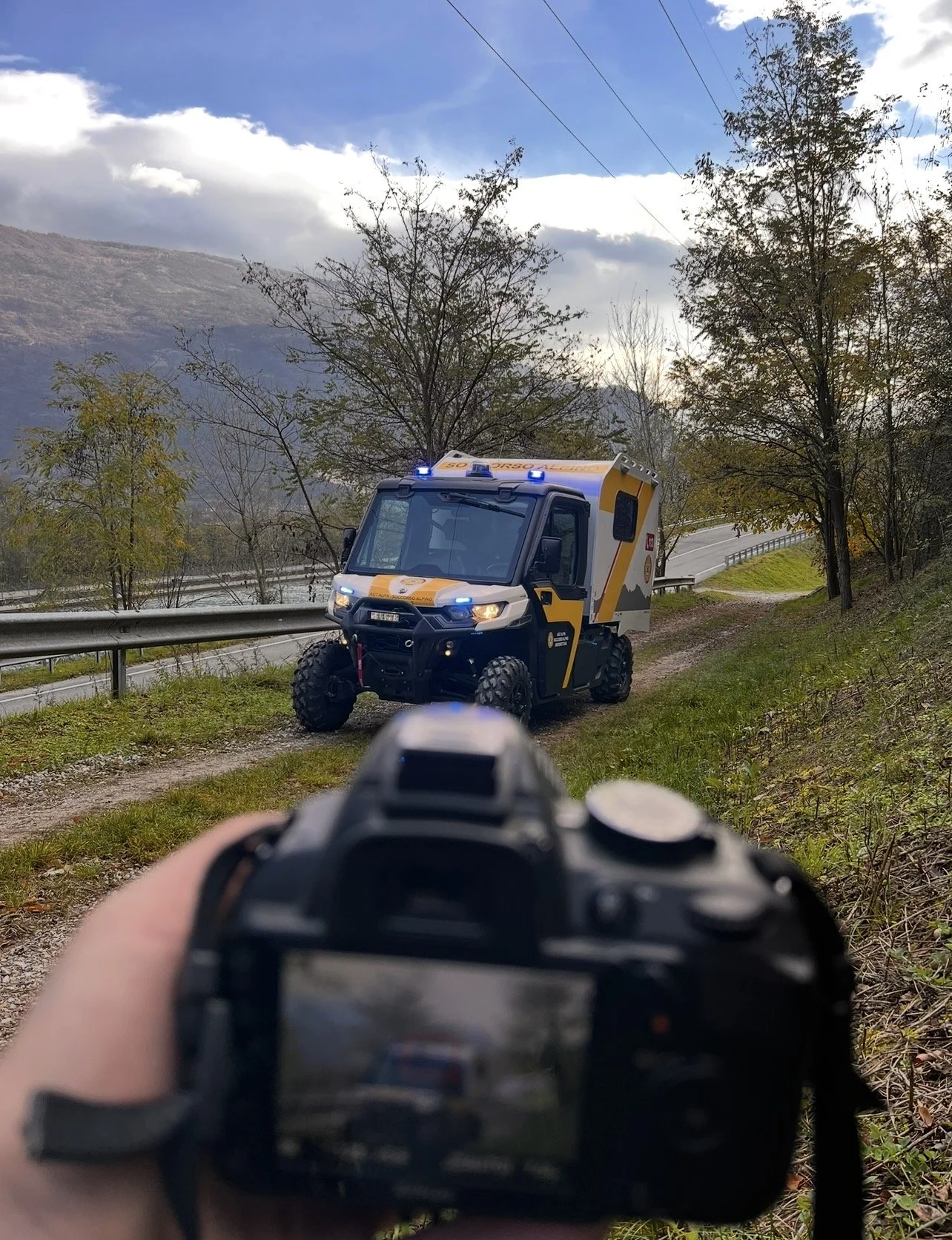 Veicolo di emergenza su un sentiero montano, vista attraverso una fotocamera puntata verso il veicolo con orsetto sulle luci di segnalazione.