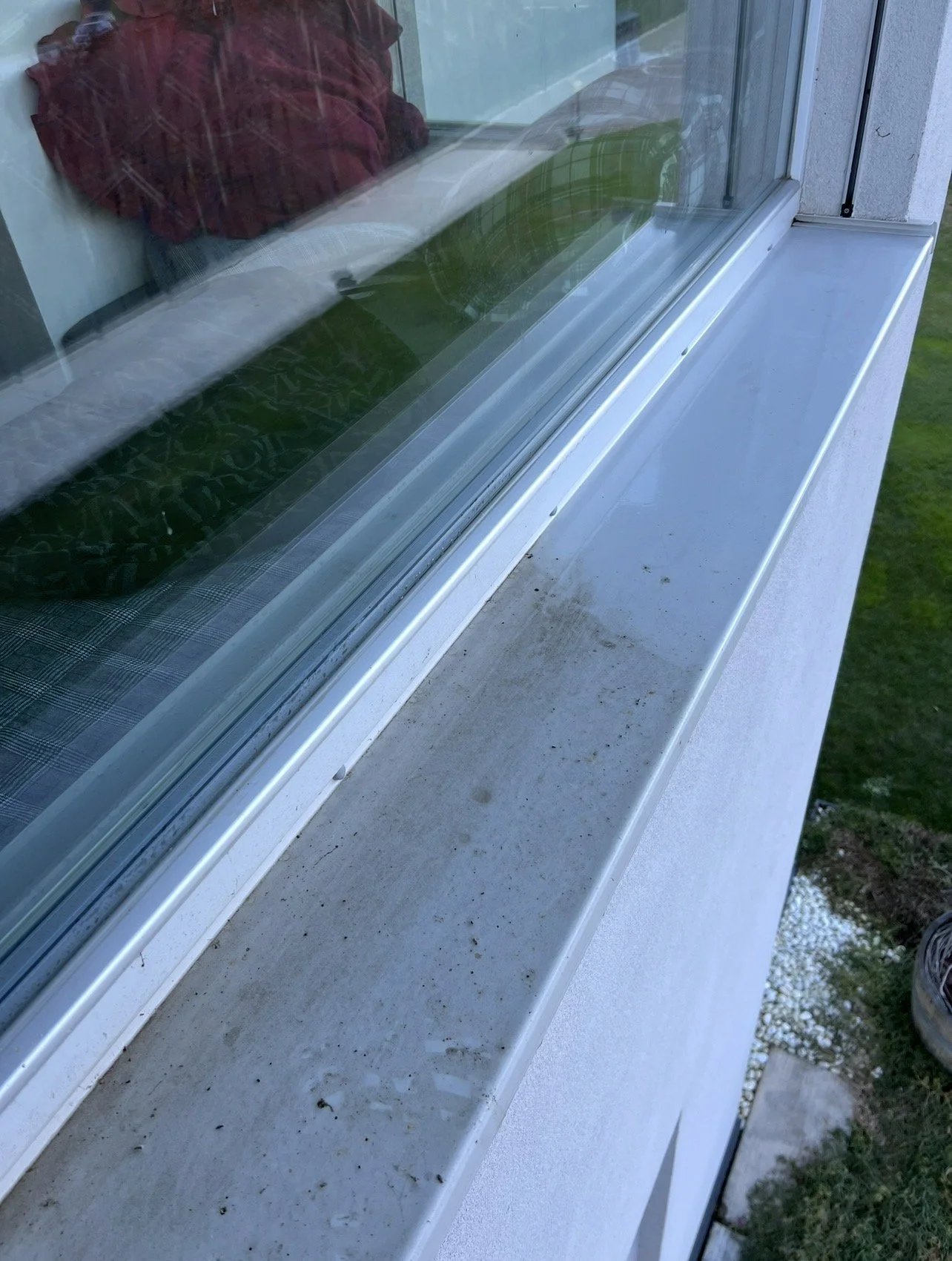 Finestra con davanzale di cemento sporco e polveroso, vista dall'esterno di un edificio