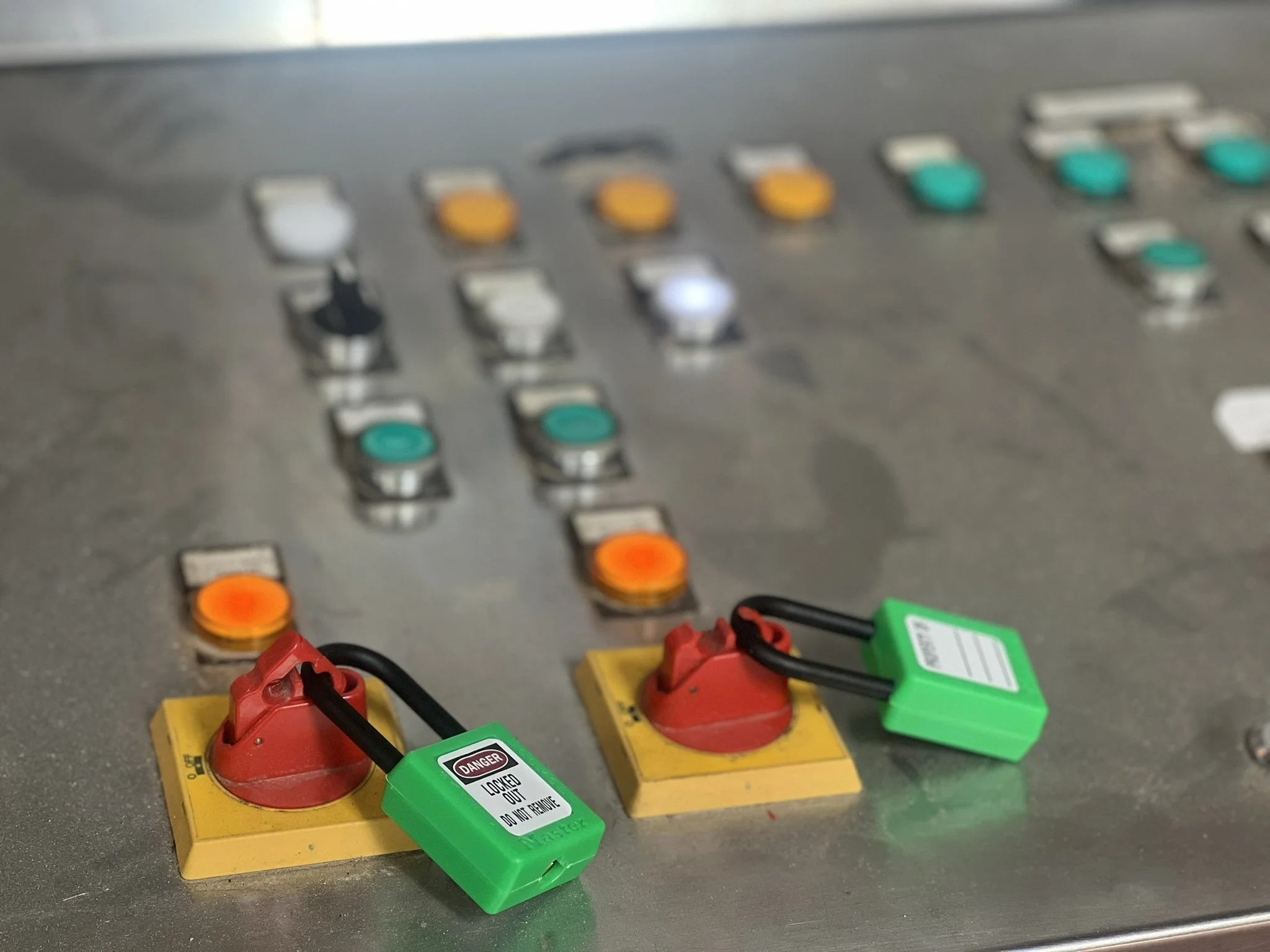 Pulsanti di controllo industriale con interruttori di sicurezza verdi e rossi, alcuni con etichette di avviso