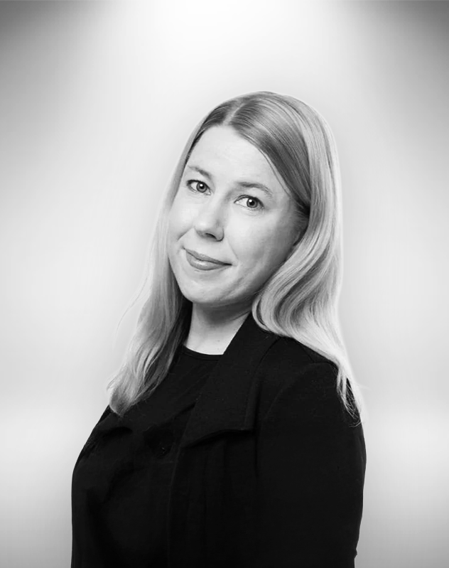 Mia Uutela henkilökuva, pukeutunut mustaan puseroon ja pikkutakkiin, hymyilee.
