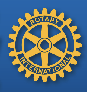 Close-up of the Rotary International logo with a yellow gearwheel and blue background.