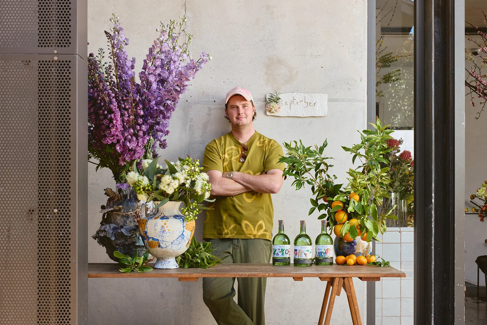 SEPTEMBER-STUDIOS-GIN-ARCHIE-ROSE-CREATOR-SERIES-BRYCE-WITH-BOTTLES-AND-FLOWERS-LO-RES.jpg