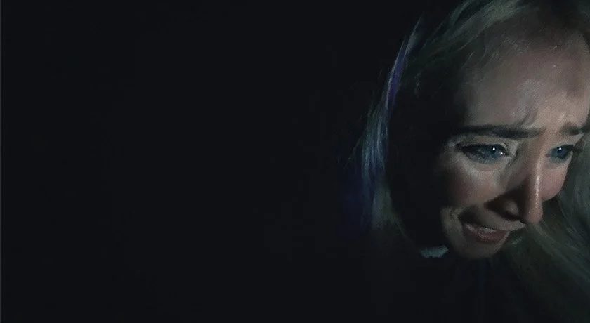 Found footage production still from Abandoned, featuring main character Jess screaming in a state of panic and emotional distress during a tense horror sequence.
