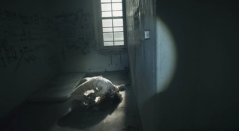 Chilling production still from the hybrid found footage horror film Abandoned, featuring character Sadie in a prison cell during a tense horror sequence.