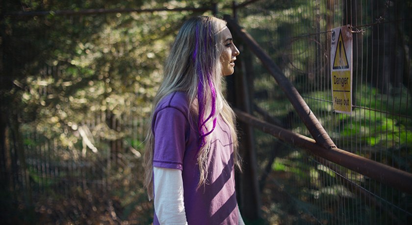 Production still from the hybrid found footage horror film Abandoned, featuring protagonist Jess staring at a "Do Not Enter" sign as the film's mystery and psychological tension begin to unfold.