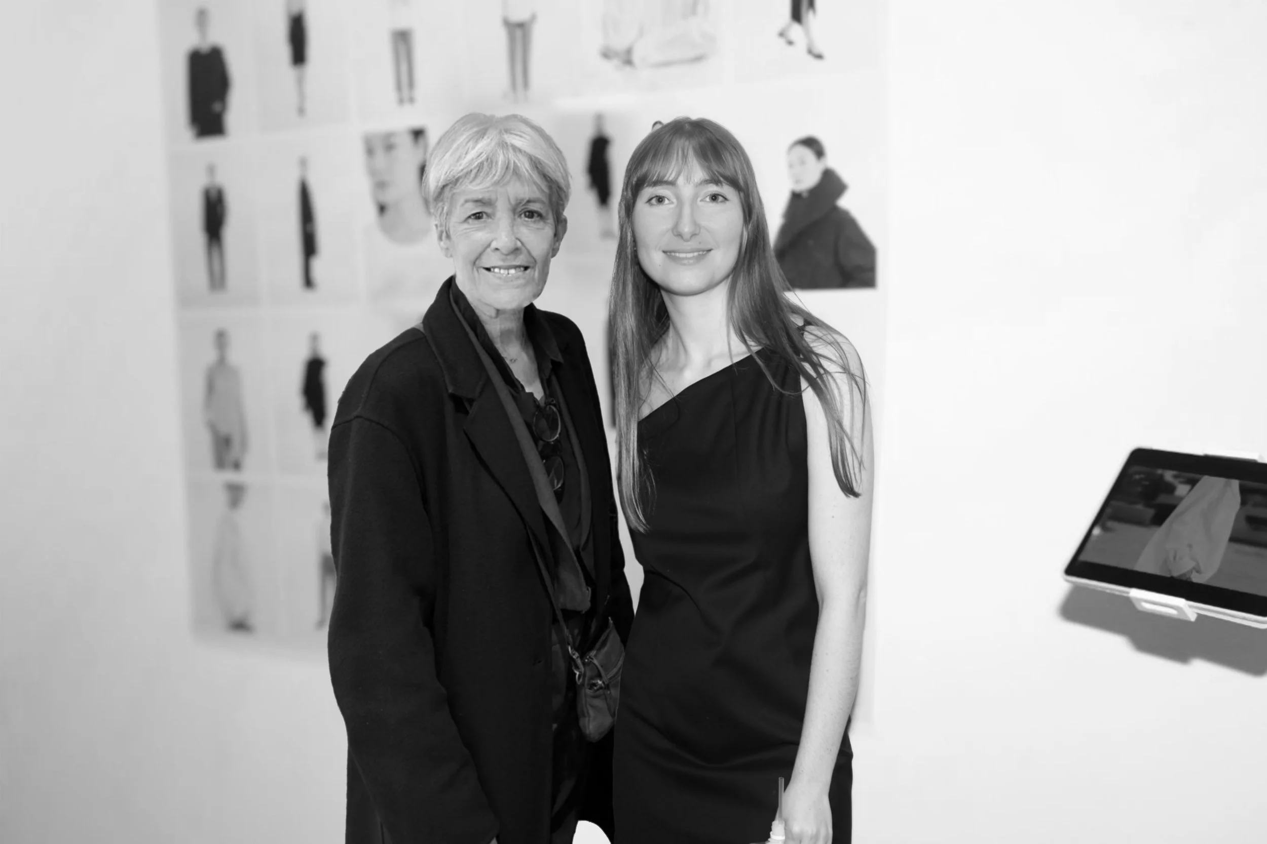 Claudie Haigneré and a young woman, Agatha Medioni posing together at an art exhibition / showroom / brand launch event with photographs on the wall behind them.