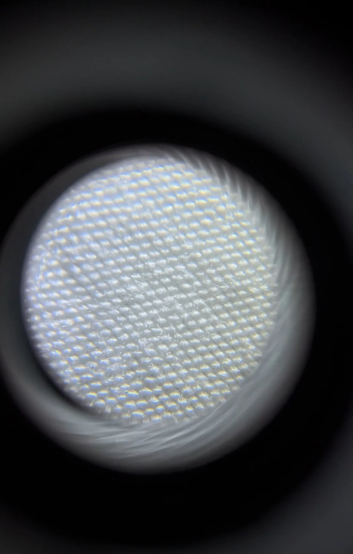 Close-up view of a textured, light-colored LED surface viewed through a circular frame.