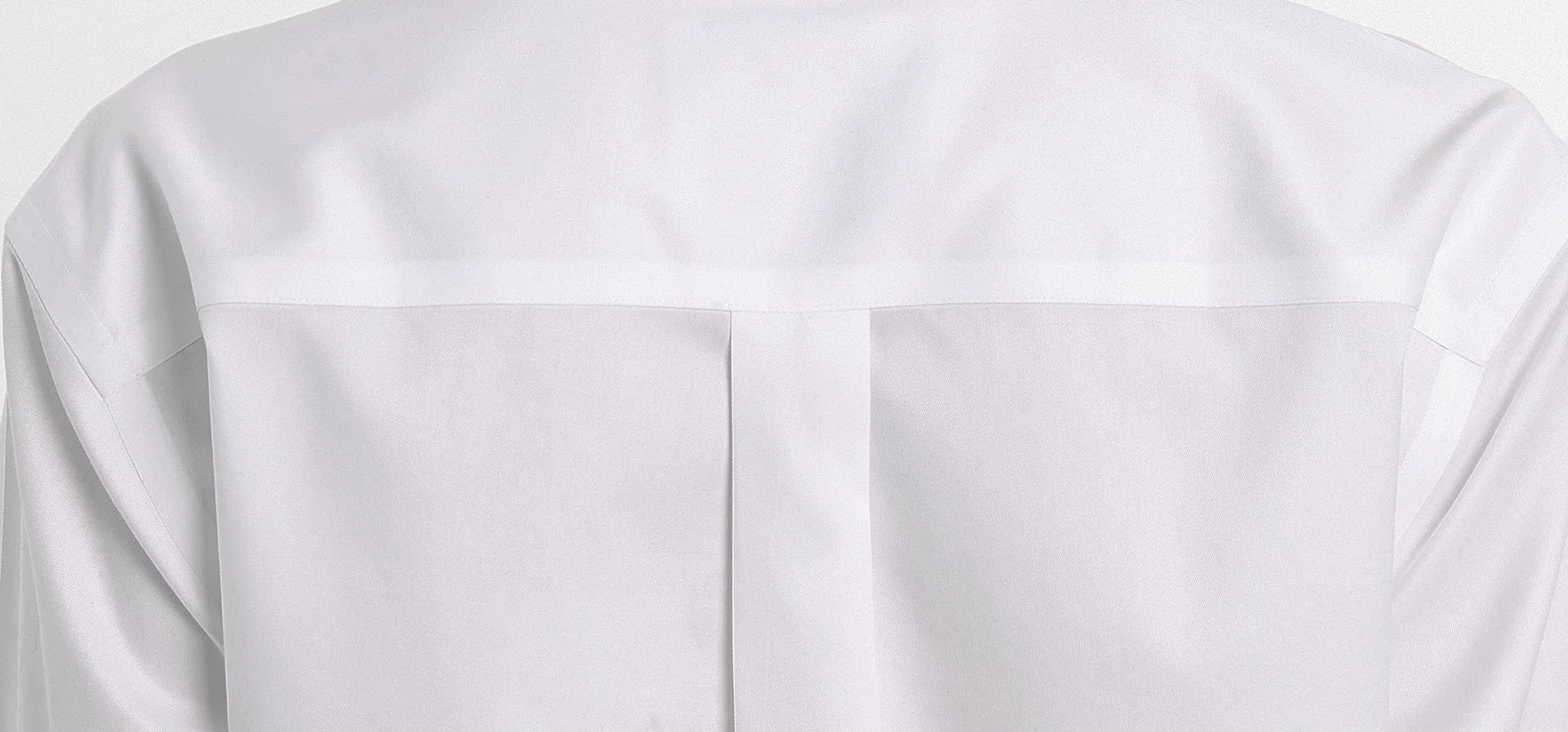 Close-up of a white shirt seam sealed finishings with a collar and buttoned front, made of smooth fabric.