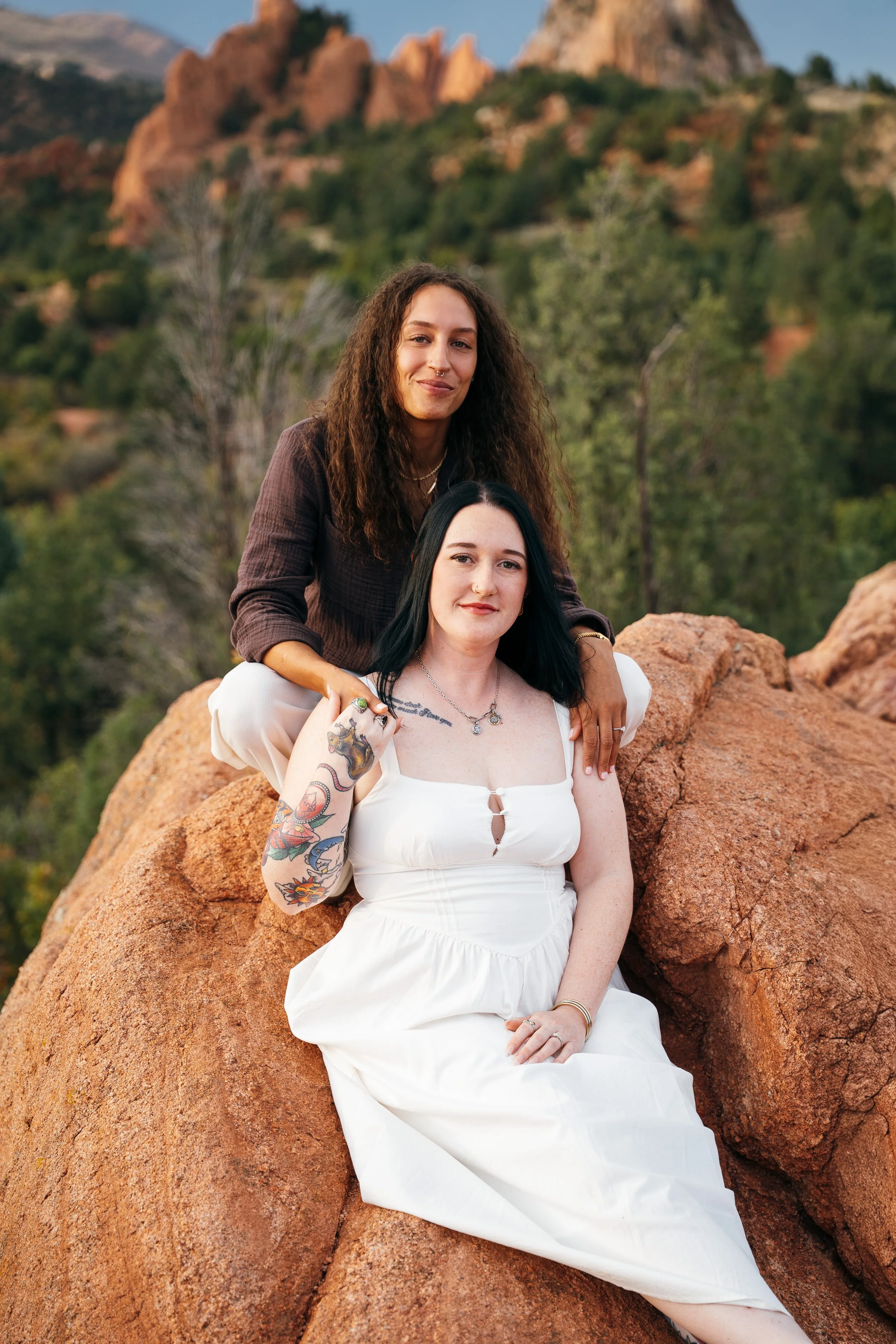  Amber and Kelsey posing together among red sandstone boulders and trees at Garden of the Gods. 