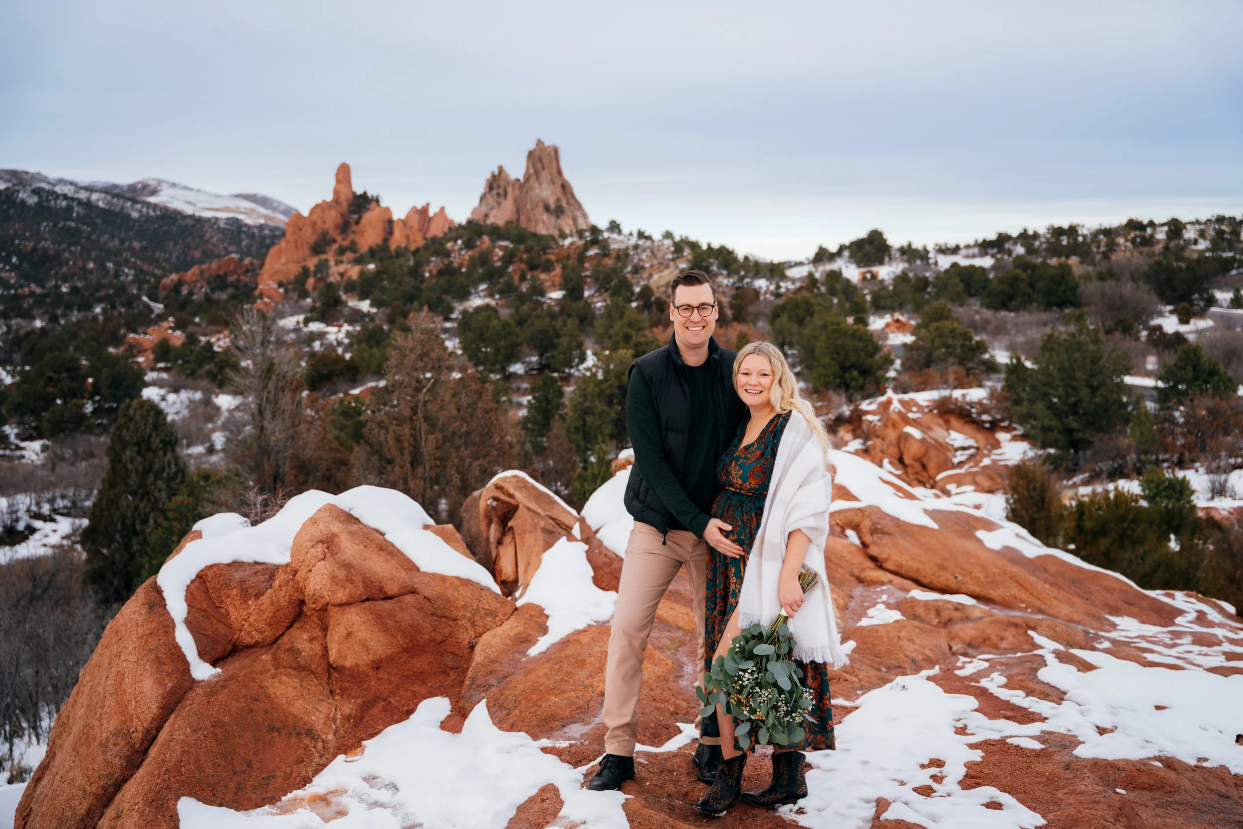 Expectant couple posing together during a January winter maternity session at Garden of the Gods in Colorado Springs.