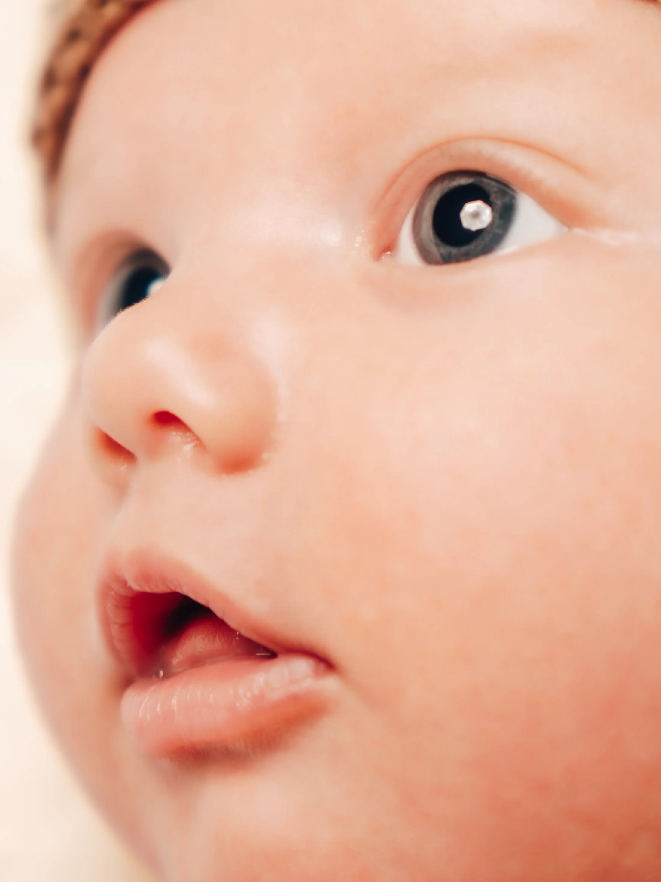 Close-up of a baby's face showing one eye, nose, and mouth.