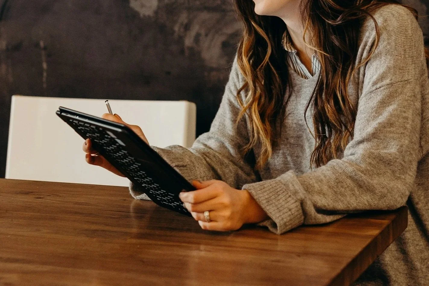 Close up of a female worker sitting at a desk with a notepad.