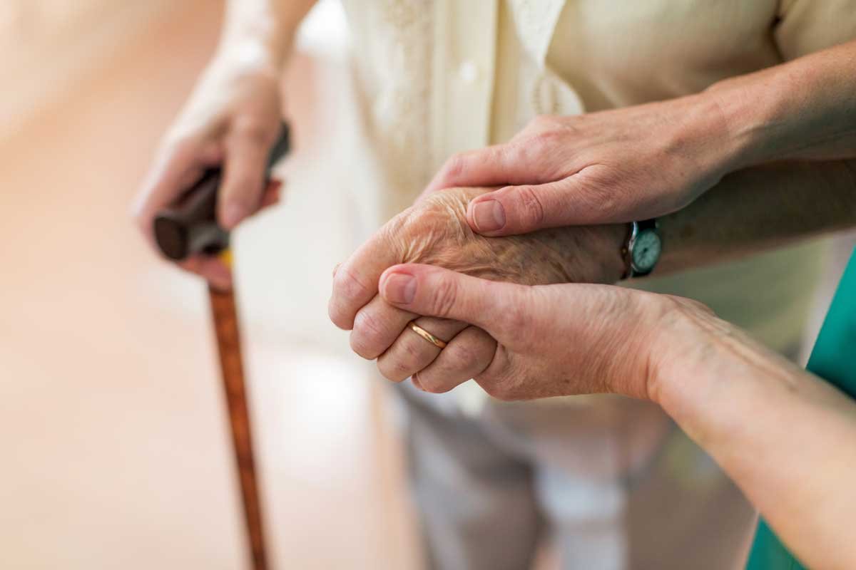 Caretaker supports elderly person with daily routines