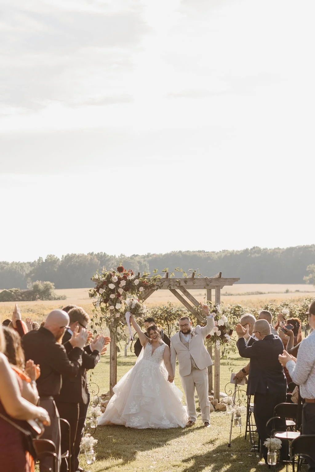Laurie’s customers, Mariana and Carmen holding hands on a green lawn on their wedding day.