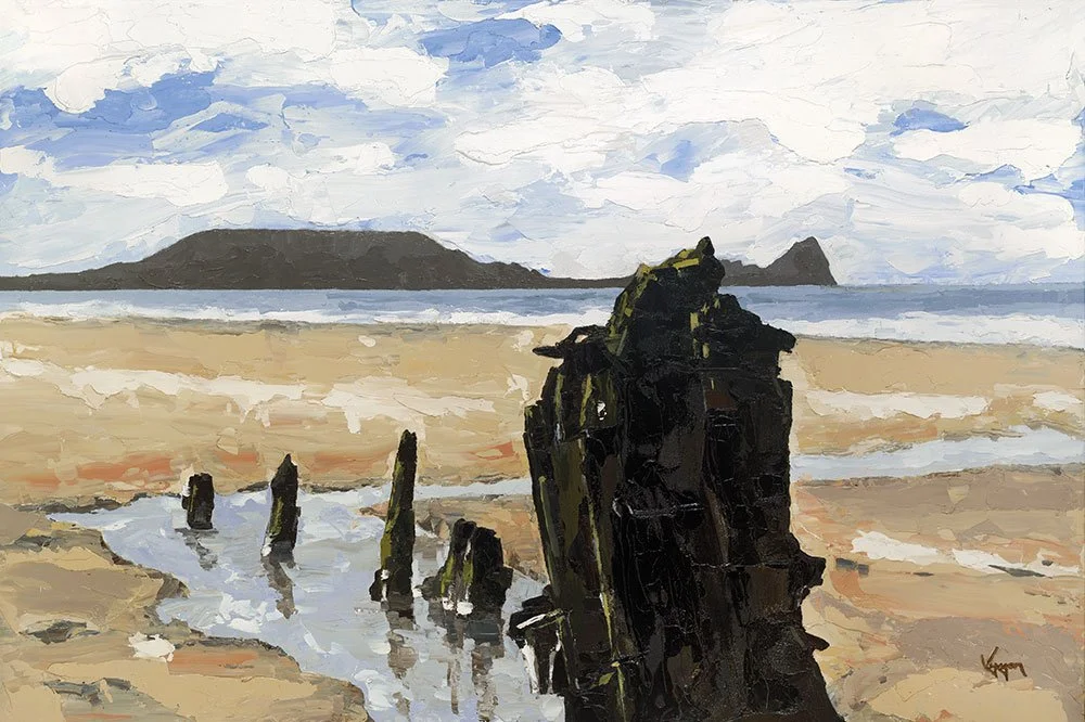 Oil painting of a beach scene with weathered wooden posts in the sand, water reflecting the sky, and a distant mountain or island under a partly cloudy sky in wales