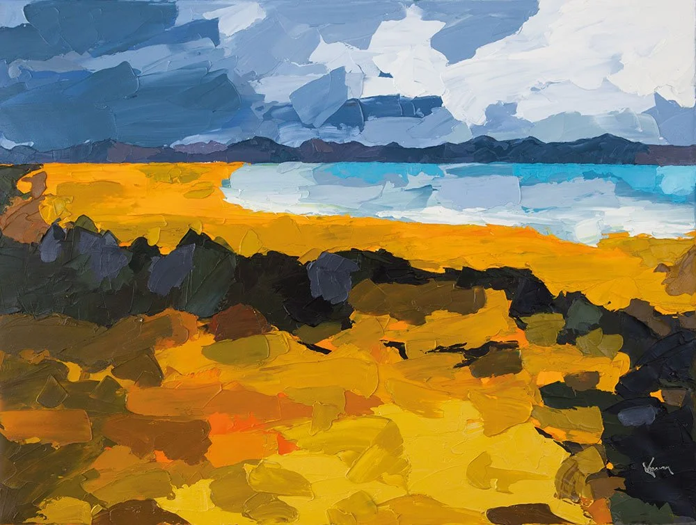 Oil painting of a coastal landscape with a yellow sandy beach, dark rocks in the foreground, blue ocean waves, distant mountains, and a cloudy sky in wales