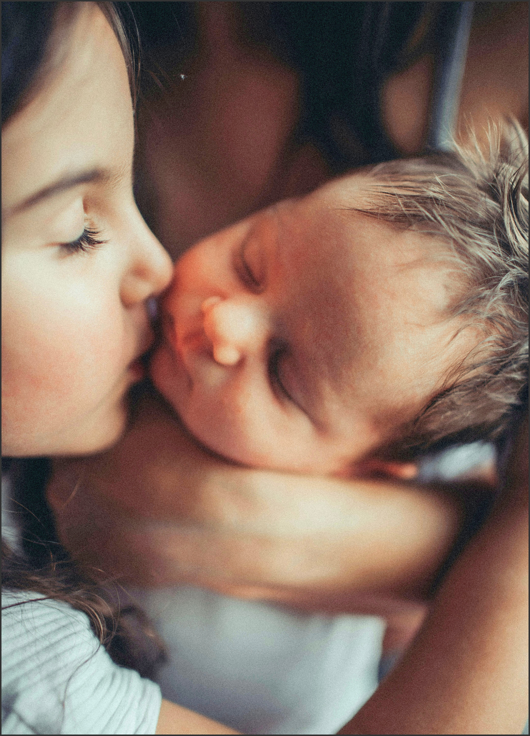A woman and a baby sharing a close, tender moment with their foreheads touching.