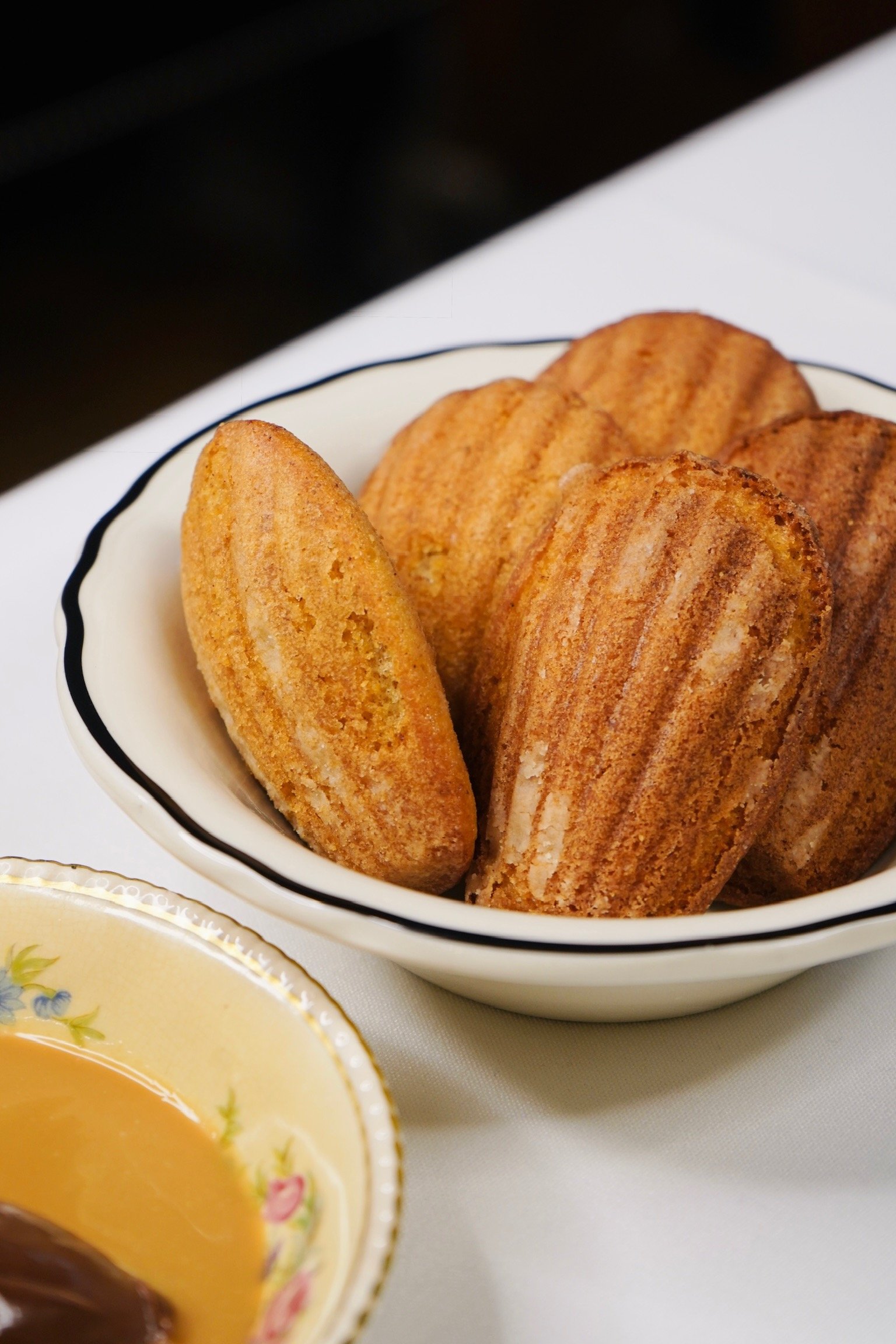 Madeleines dans un bol blanc avec une ligne noire