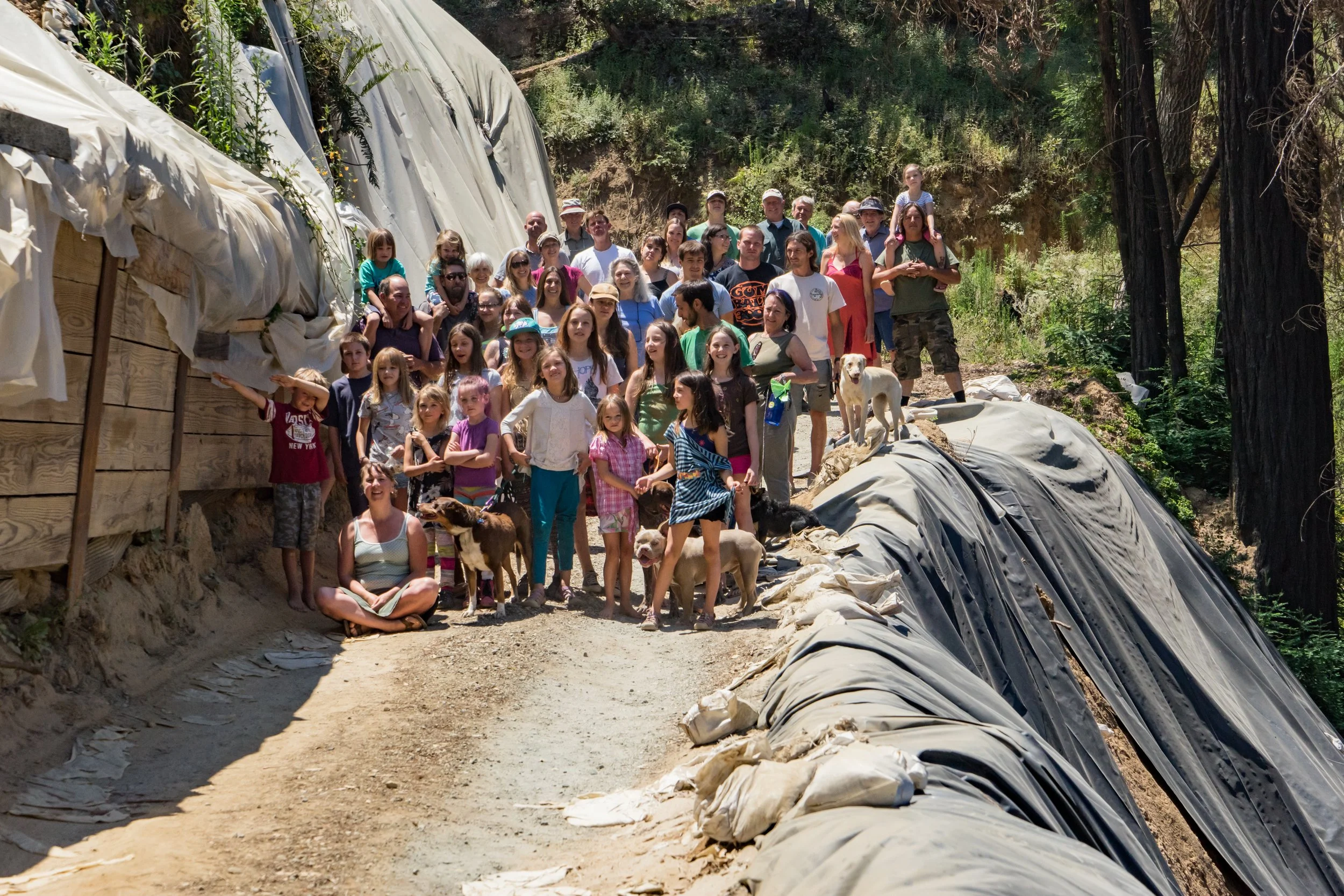 A group of people standing on an unrepaired dirt road