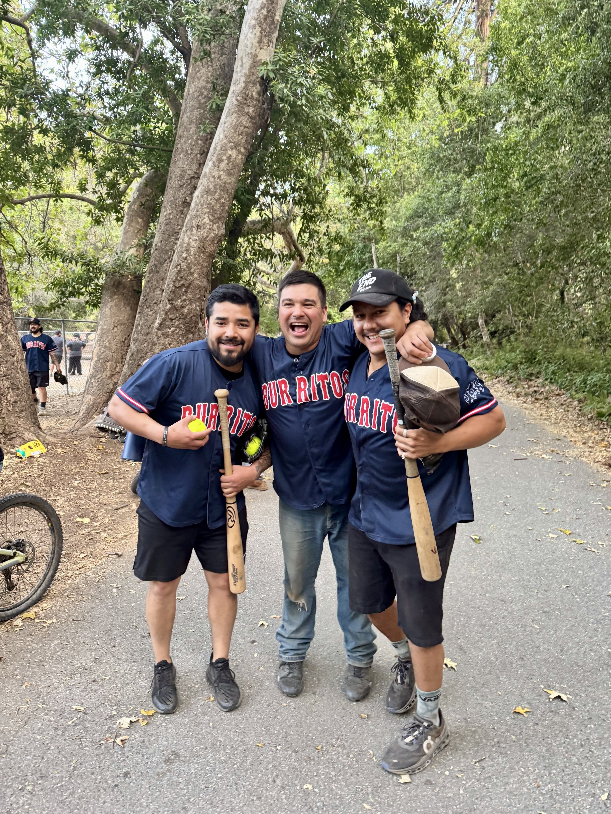  Three men smiling in softball uniforms 