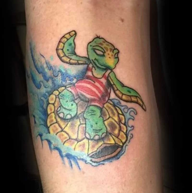 Colorful tattoo of a cartoon turtle with a lizard head, wearing a red and white striped shirt, surrounded by water splashes.